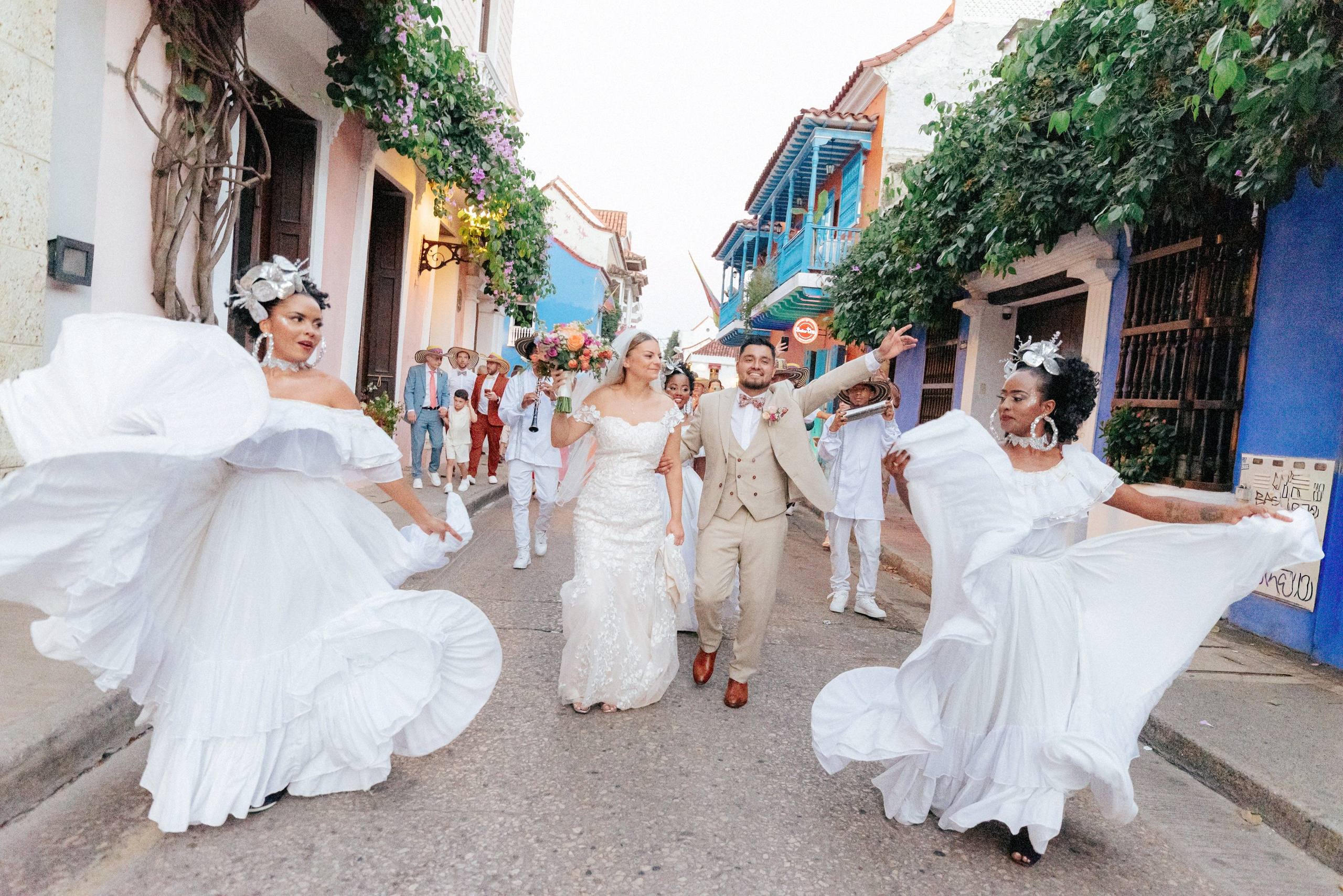 Brides walking down street together – “Group of brides walking joyfully down a colorful street in Cartagena, fun and lively wedding photography