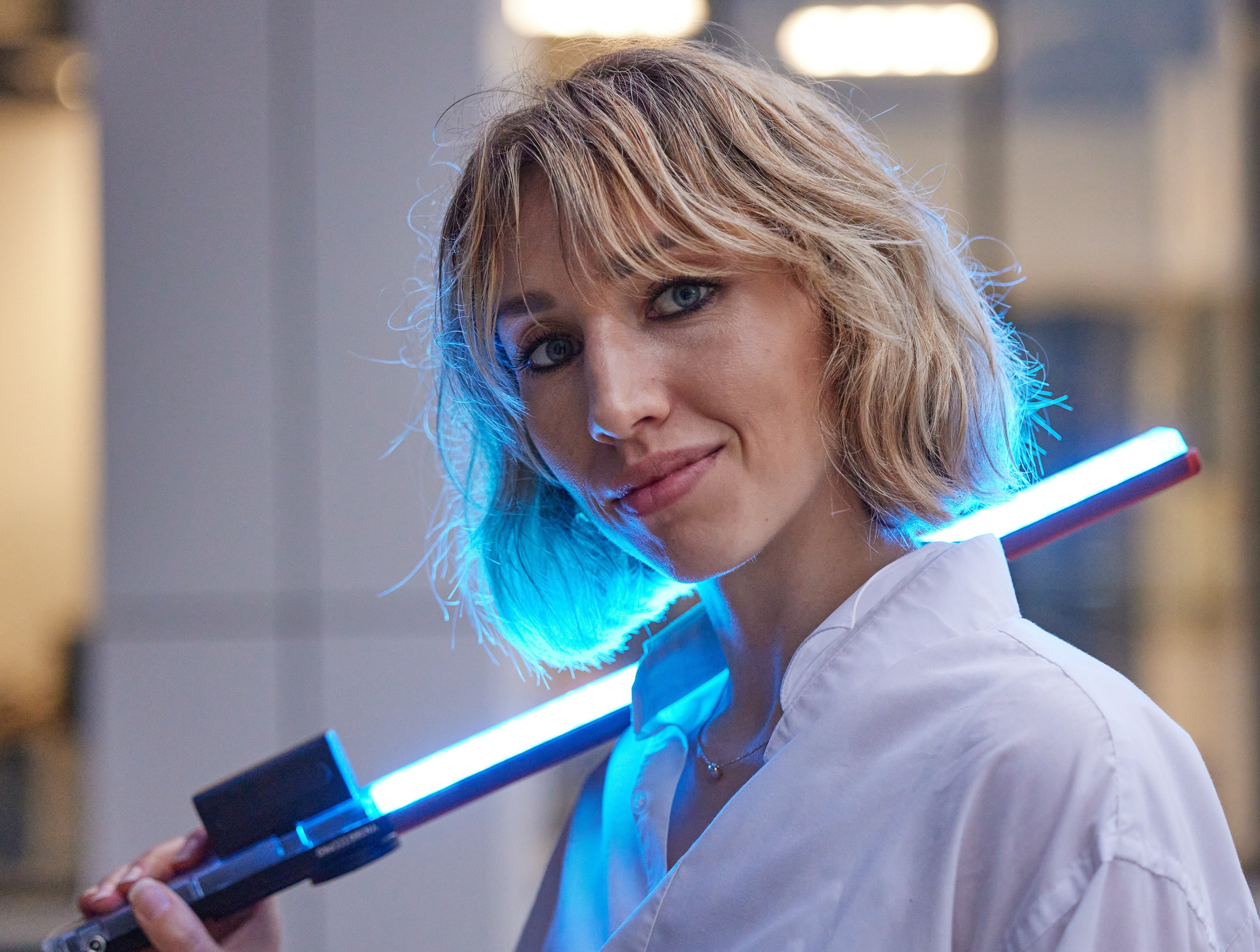 Location portrait of a young woman with colored lighting against the backdrop of a building - photographer Andrey Dunin