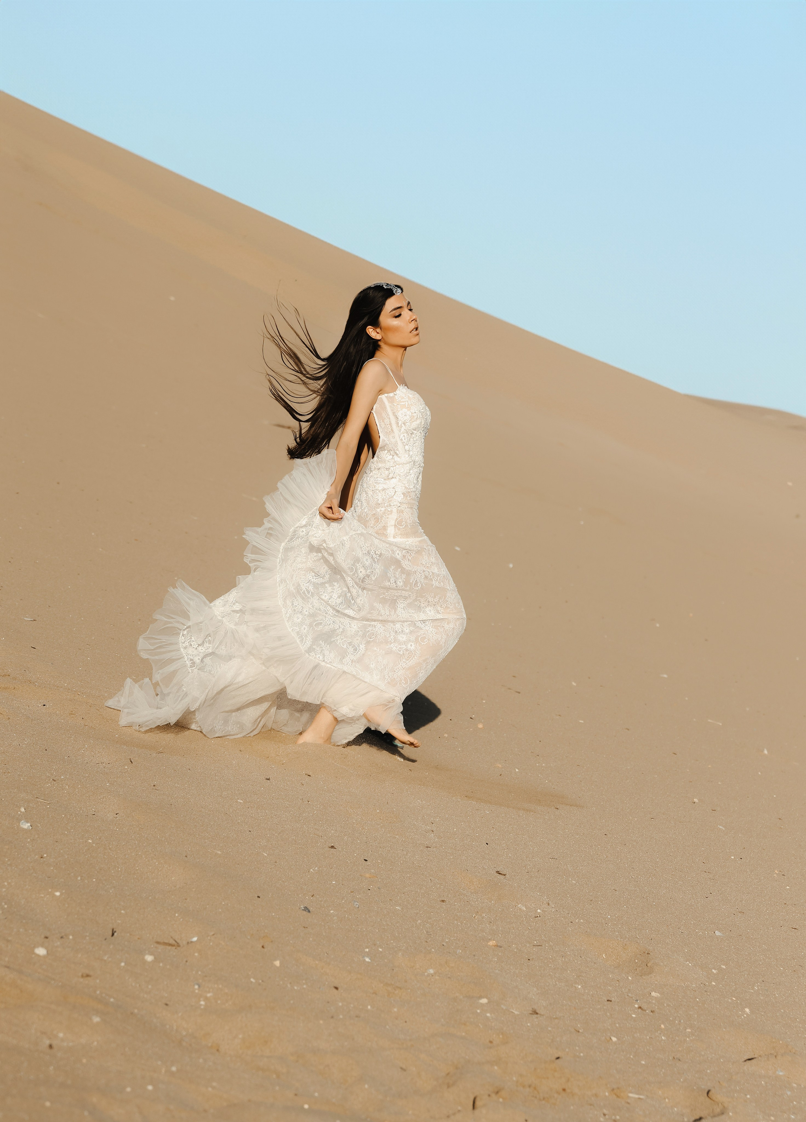 Art photoshoot of a girl in a wedding dress in the desert on a beach Tsampika in Rhodes