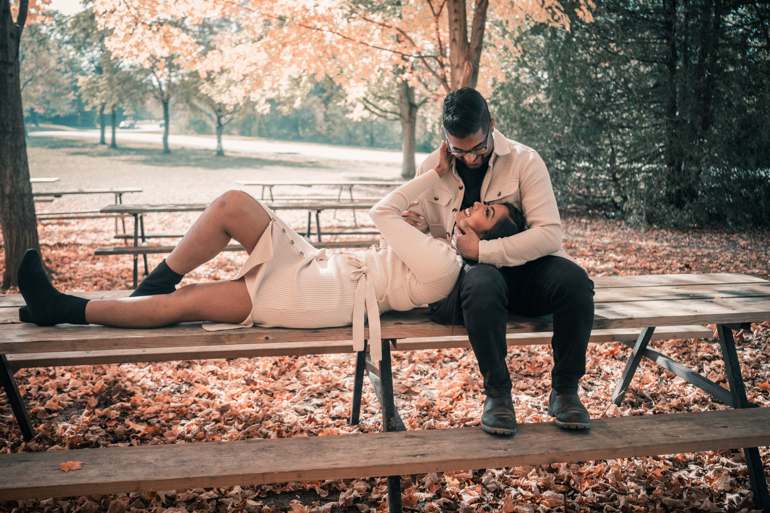 Couple walking through a golden autumn park, capturing their engagement moments