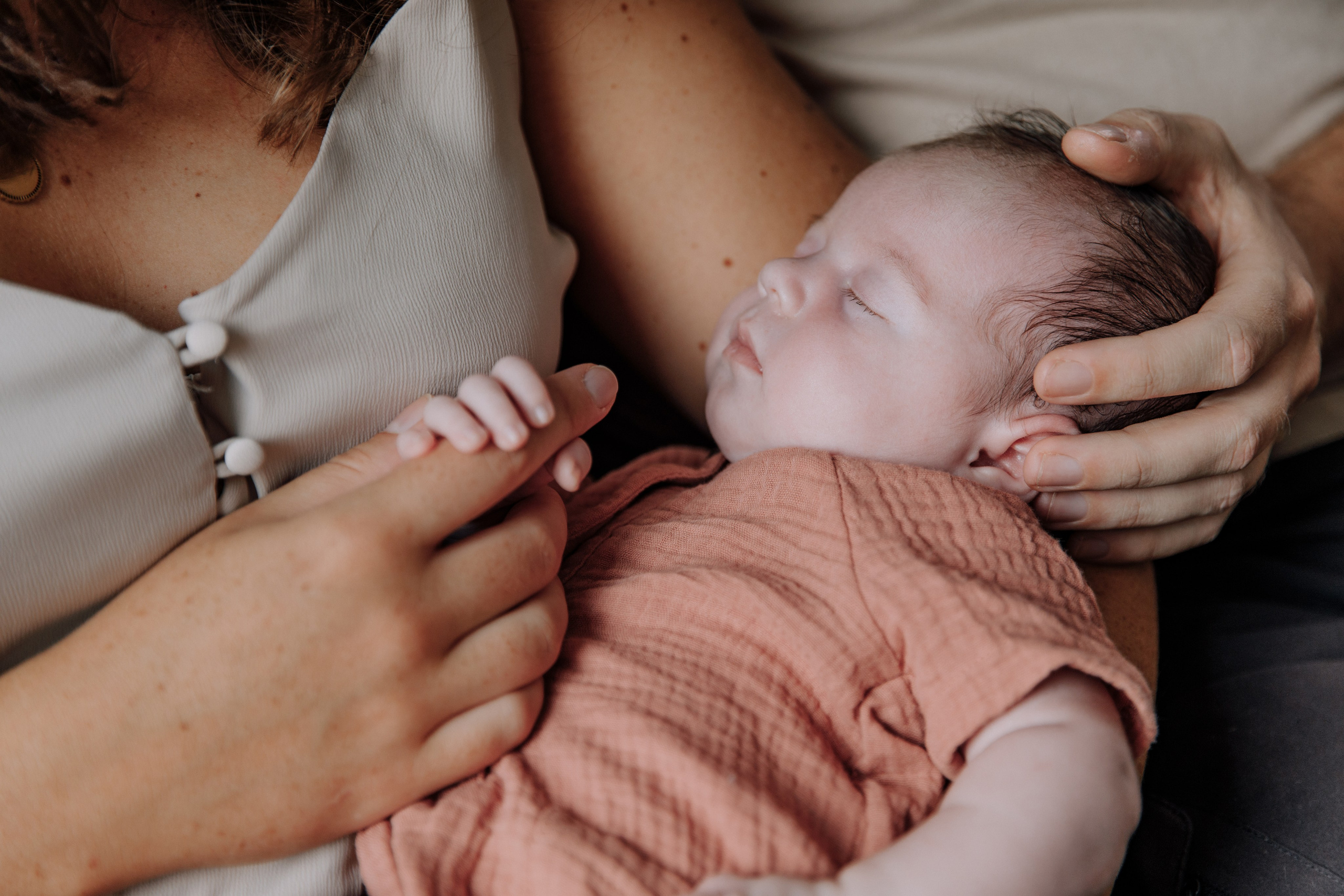 Eltern halten die Hand ihres Babys.