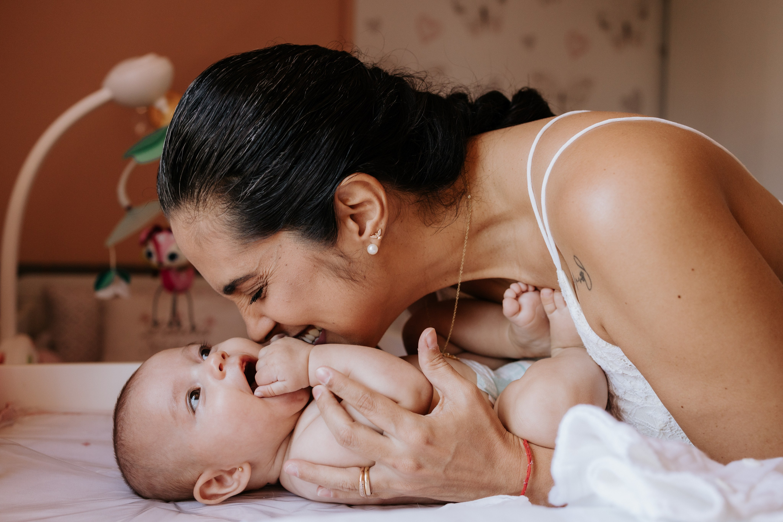 Mãe dando cheiro na filha bebê de 3 meses