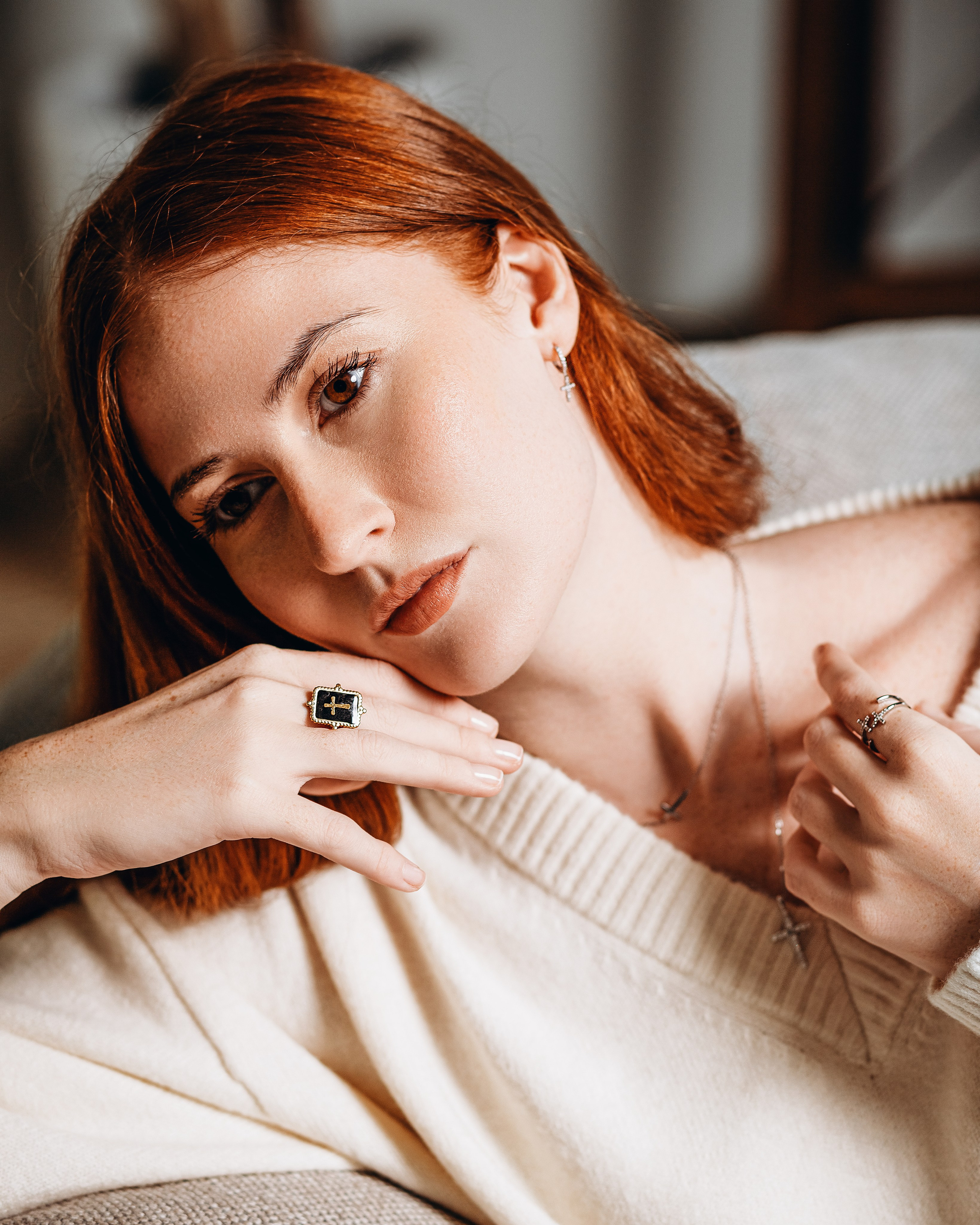 Elegant brand portrait of a young woman with auburn hair, showcasing minimalist cross jewelry and a bold black ring, captured during a content-focused product photoshoot in Valencia, Spain — ideal for brands seeking refined lifestyle and jewelry photography in Spain.