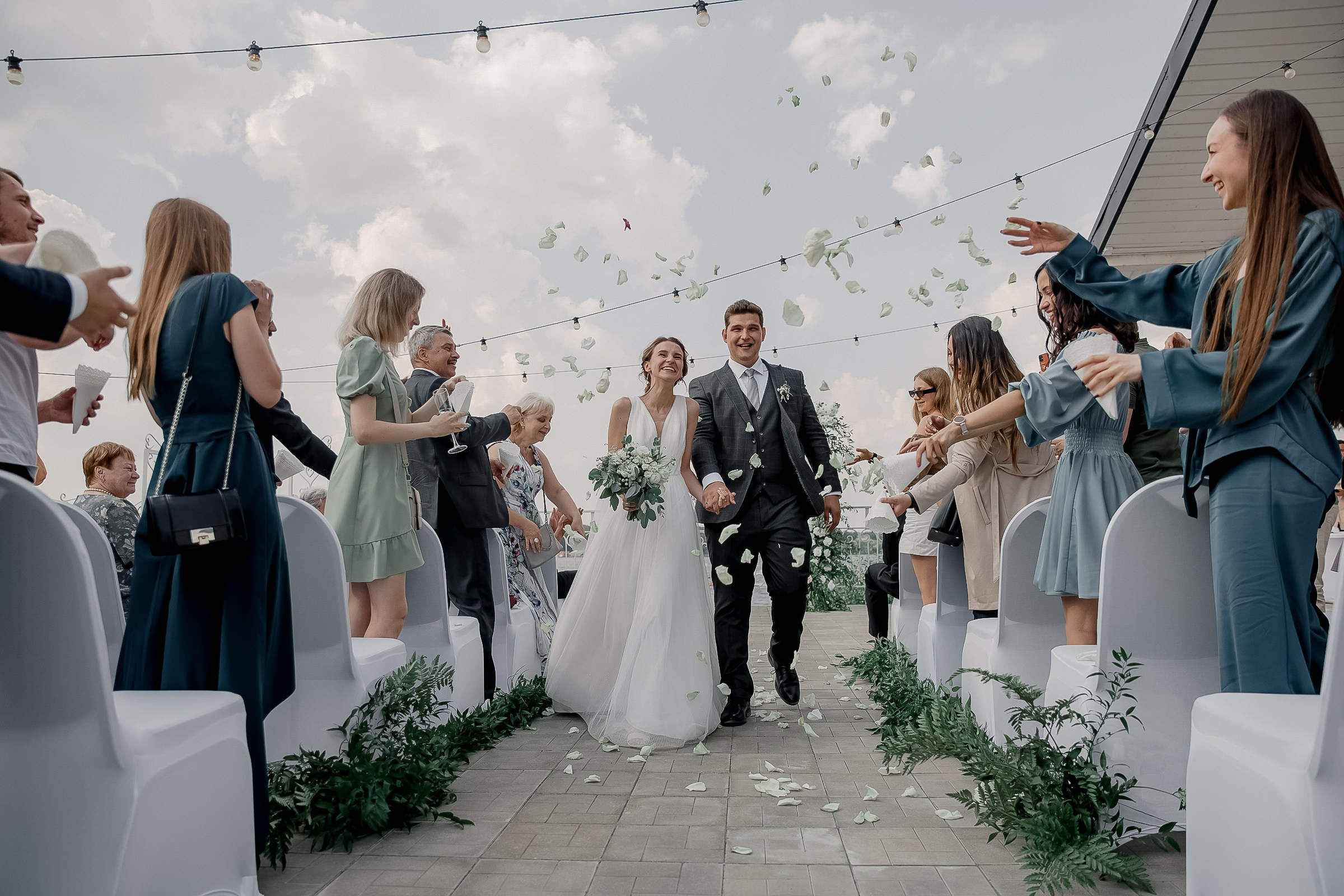 Couple exiting ceremony with confetti, by Bude, Cornwall wedding photographer.