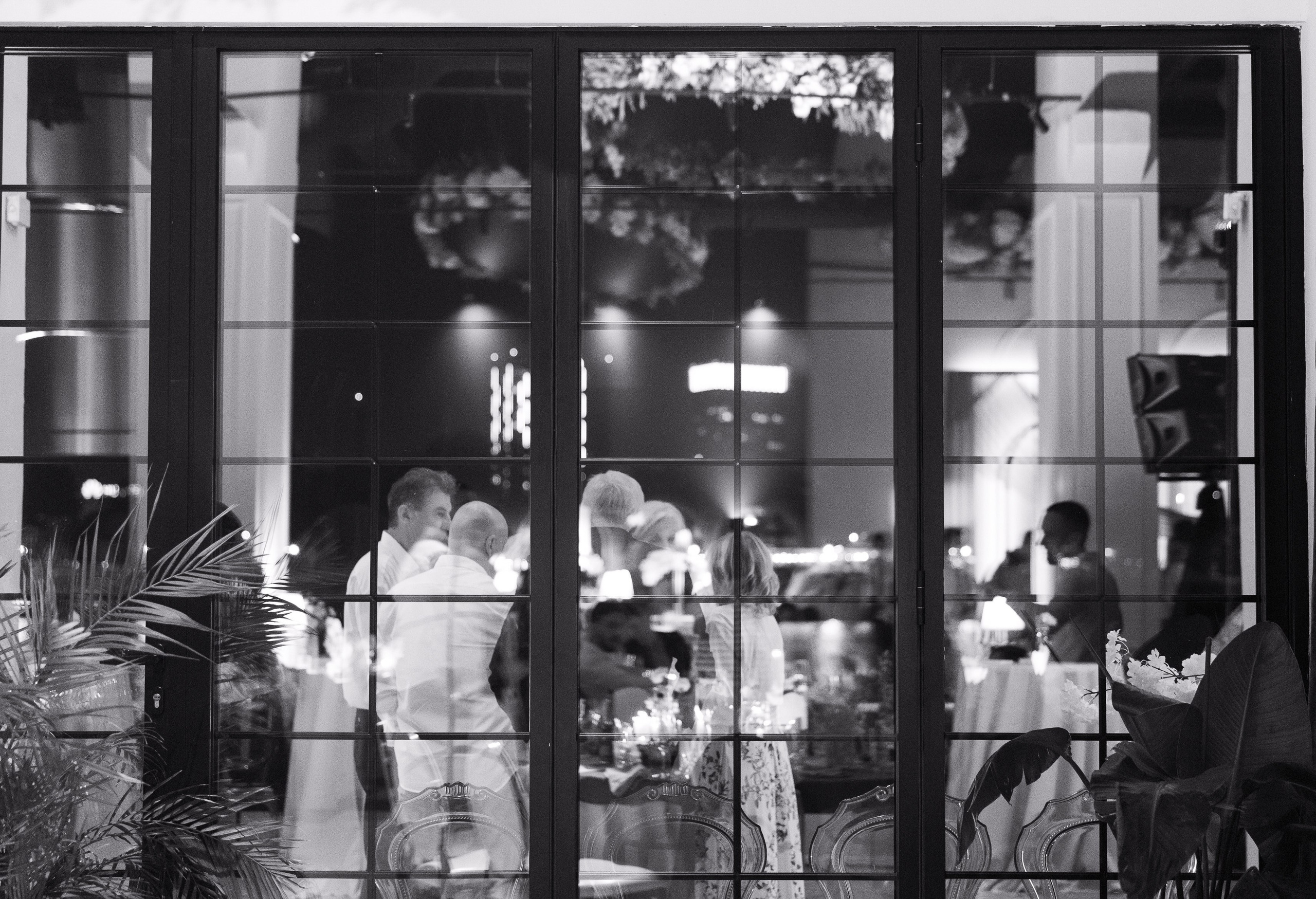 Judi koji se vesele na svadbenoj proslavi, fotografisana atmosfera kroz prozor