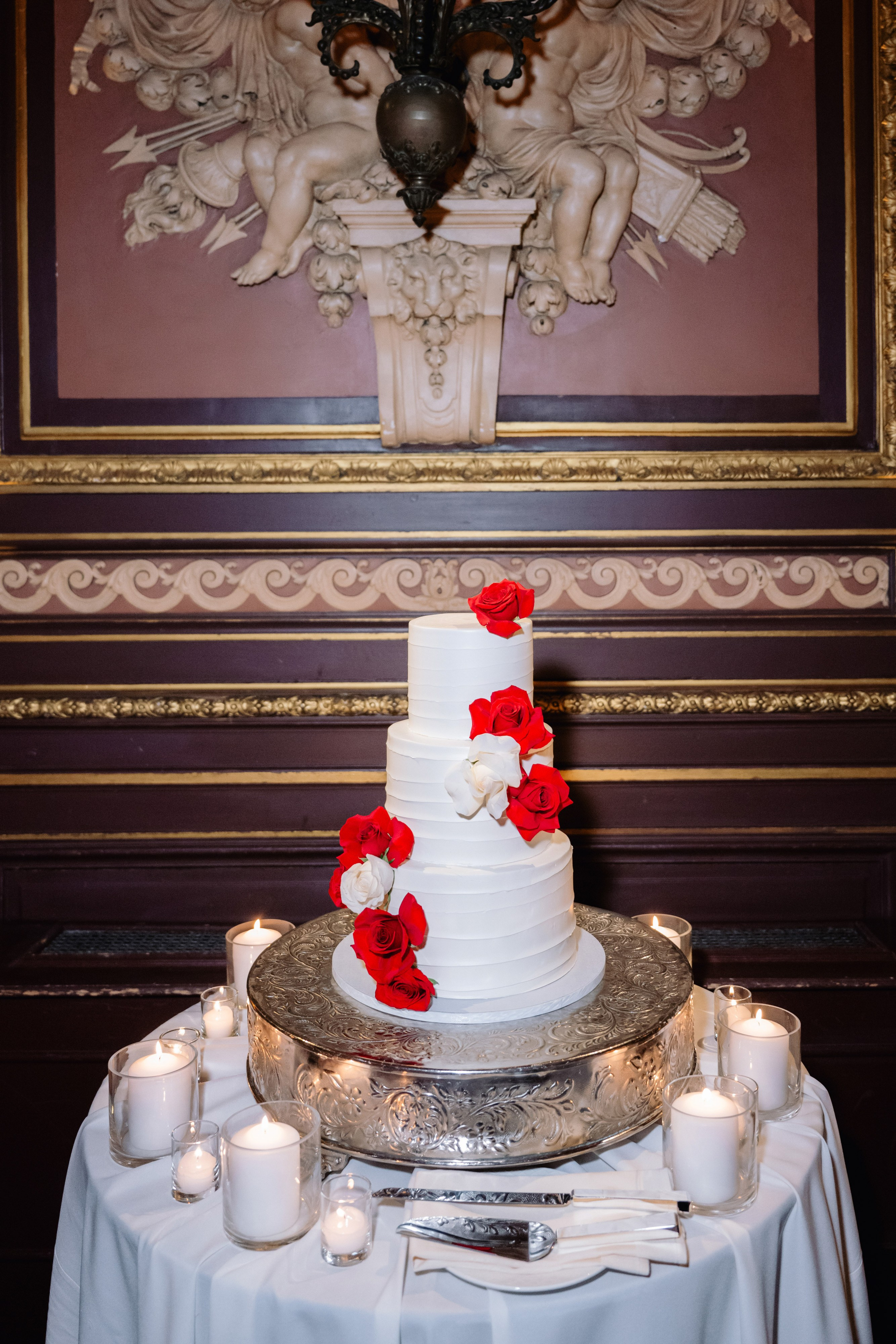 a white cake with red roses on top