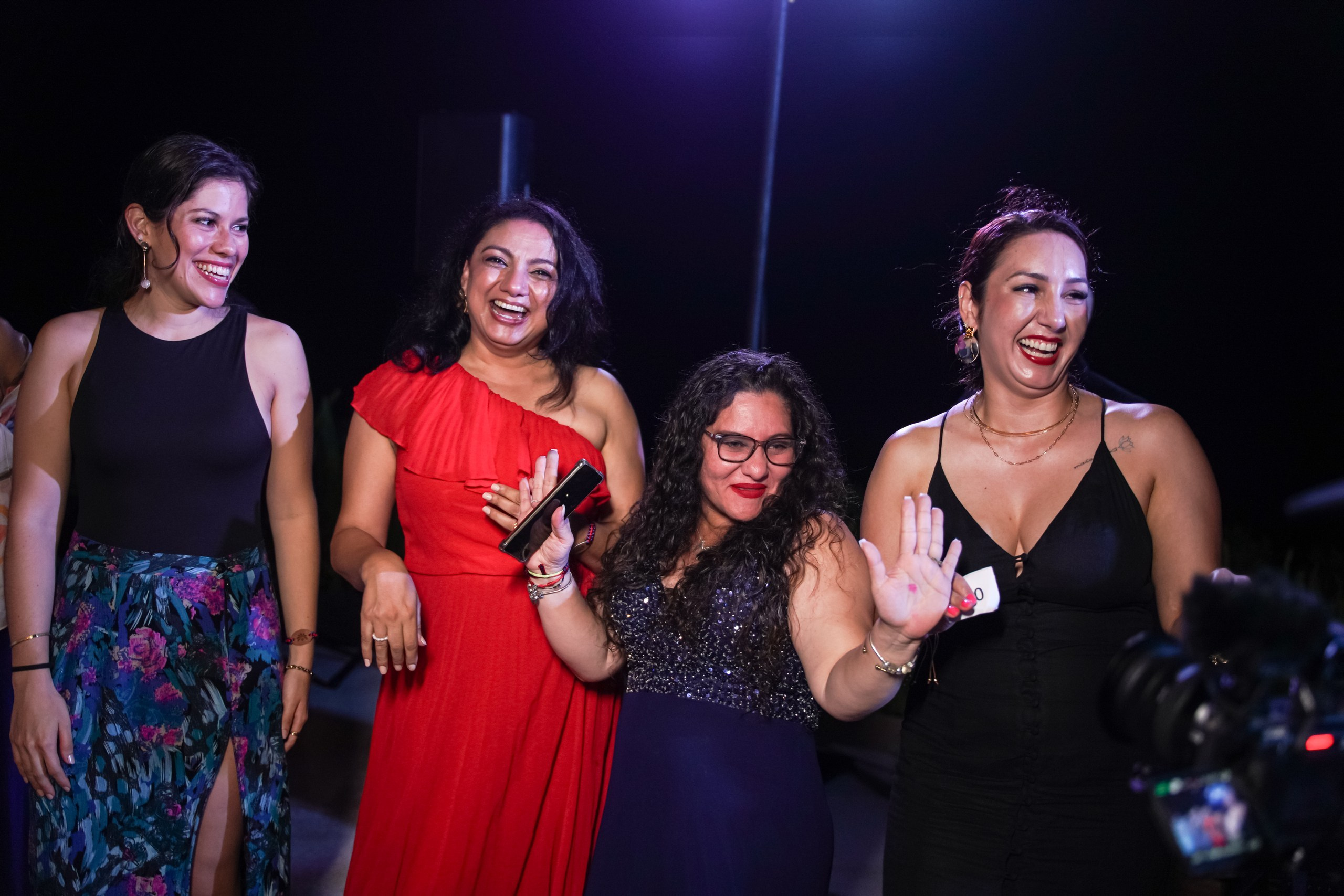 Winners smiling with gift bag during award presentation.