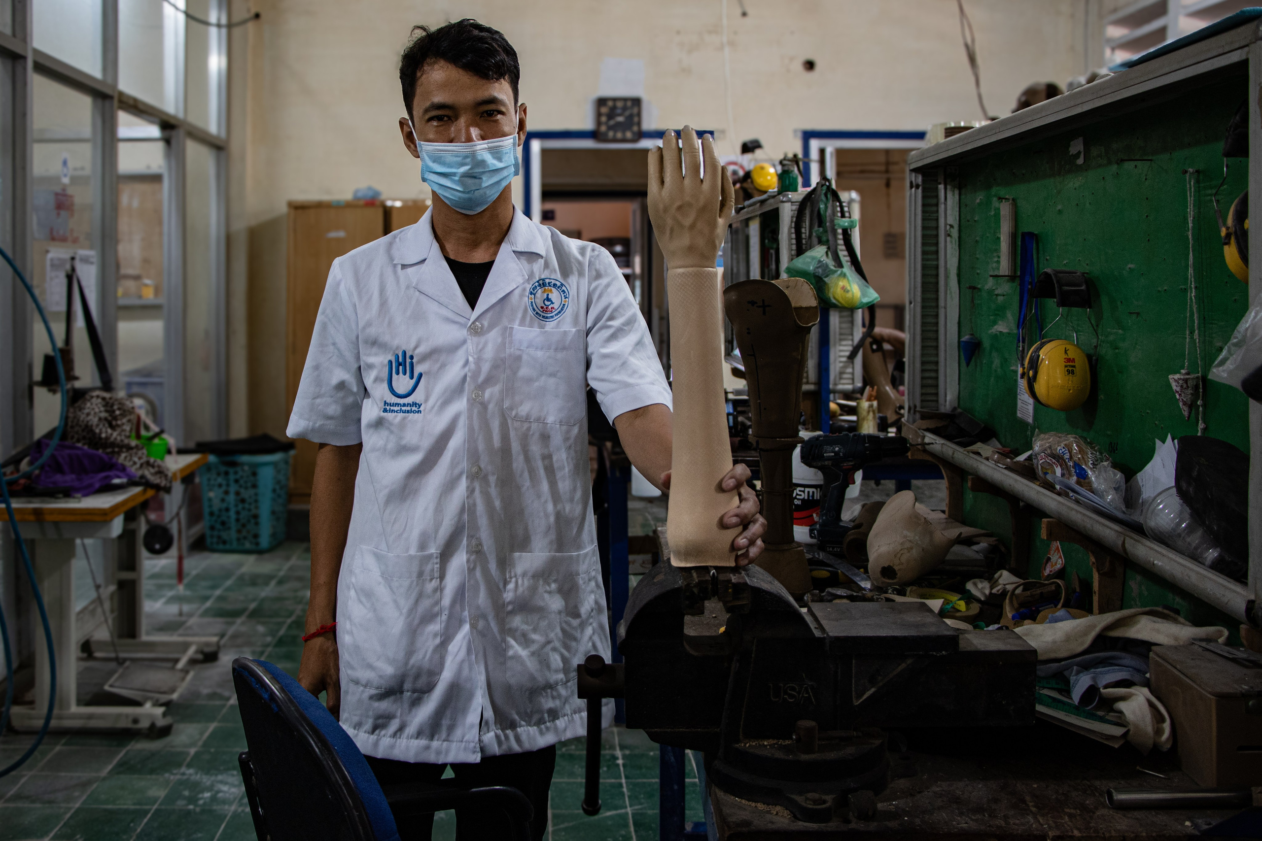 Un employé de Handicap International travaillant dans l’atelier de prothèses du centre de réhabilitation de Kampong Cham, offrant un soutien essentiel aux personnes handicapées locales dans le processus de réadaptation.