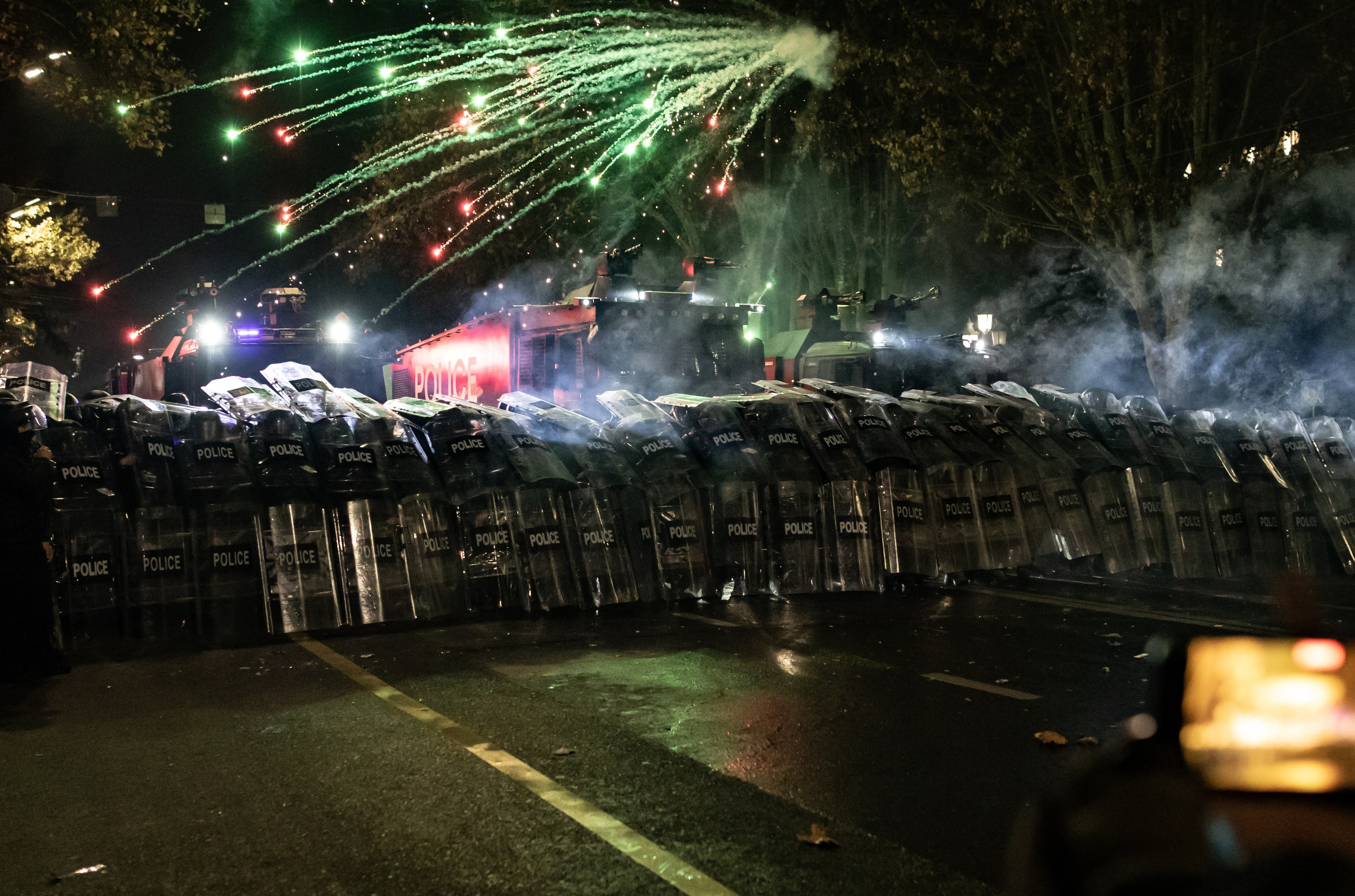 Les manifestants tirent des feux d’artifice sur les forces de l’ordre, protégées par leurs boucliers devant le Parlement.