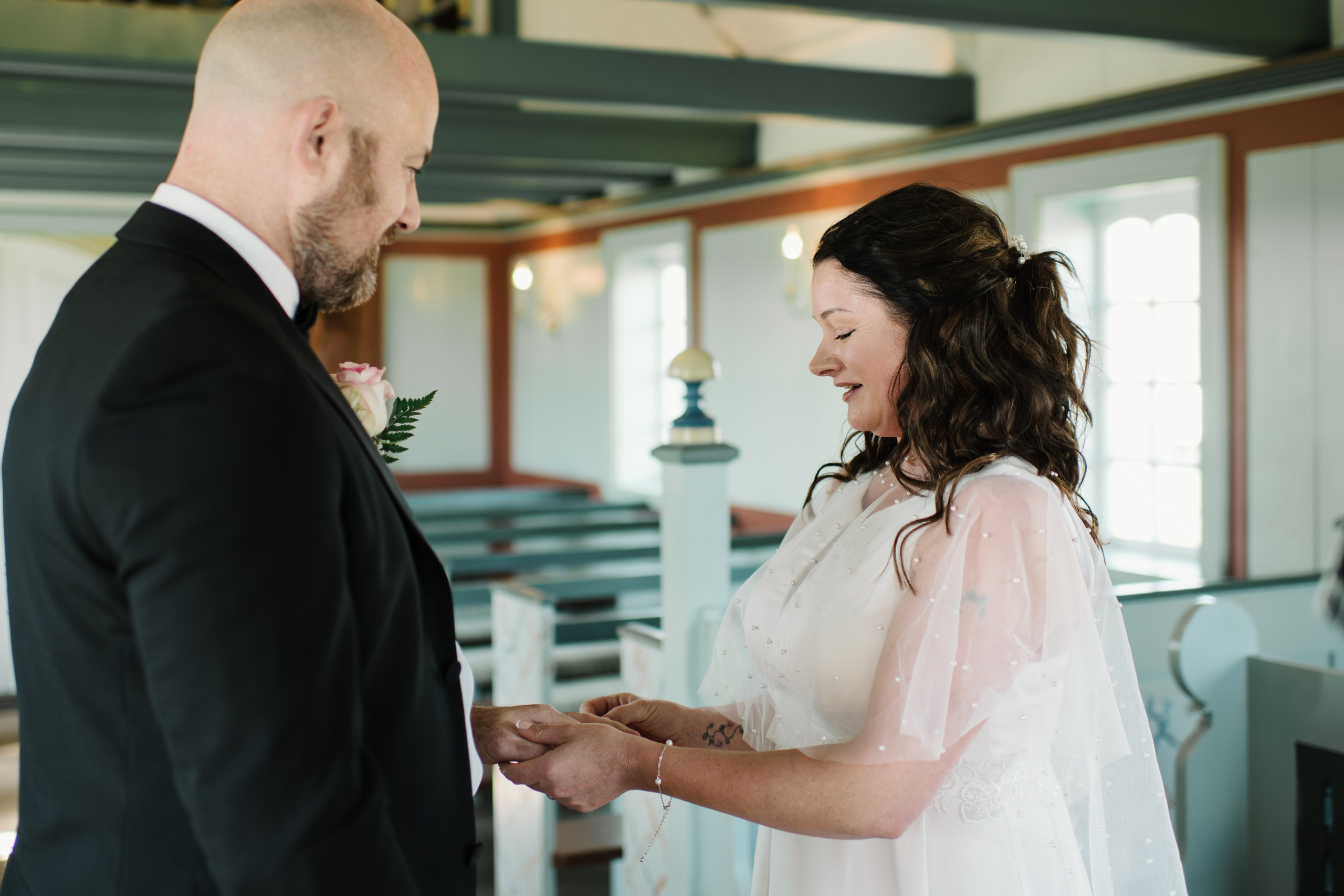 Newlyweds walking towards Búðakirkja, with the wild Icelandic coastline stretching behind them.