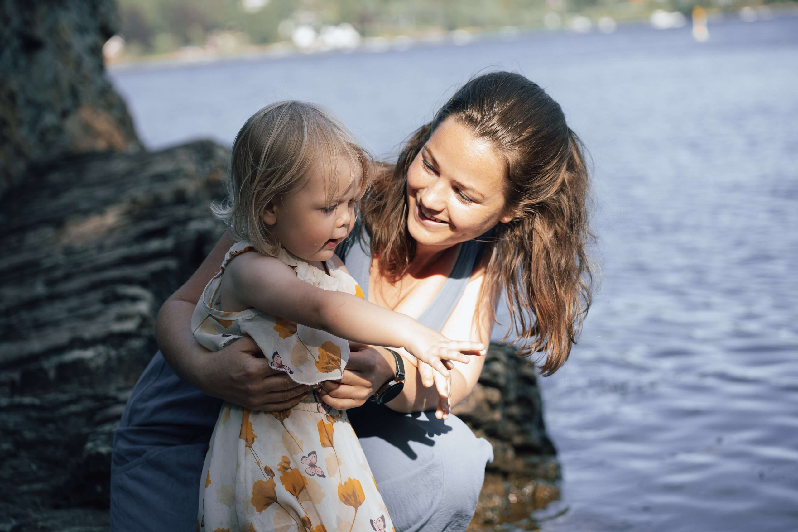Mor og datter ved vanne smiler til hverandre