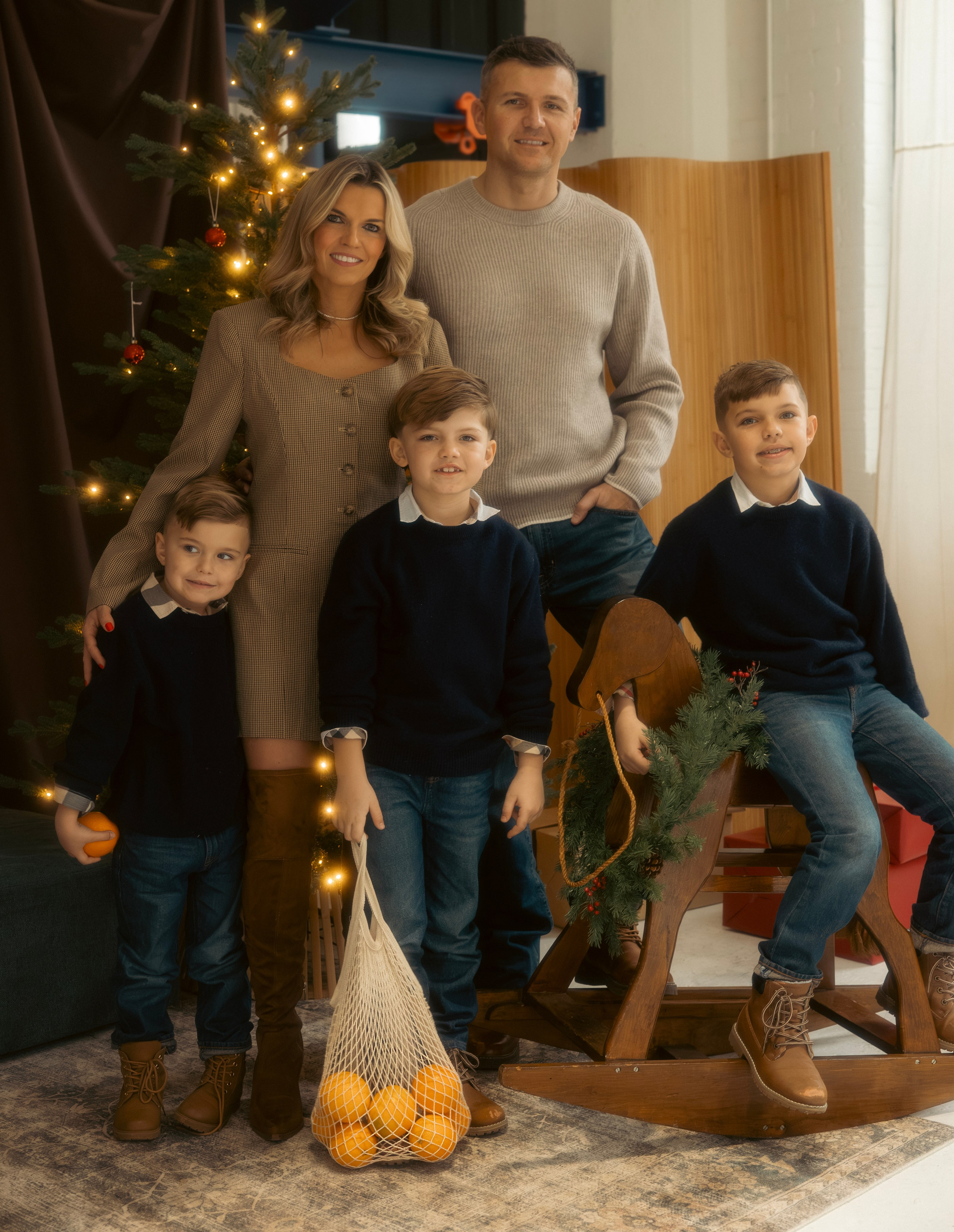 Family sitting together by the Christmas tree during a holiday photo session