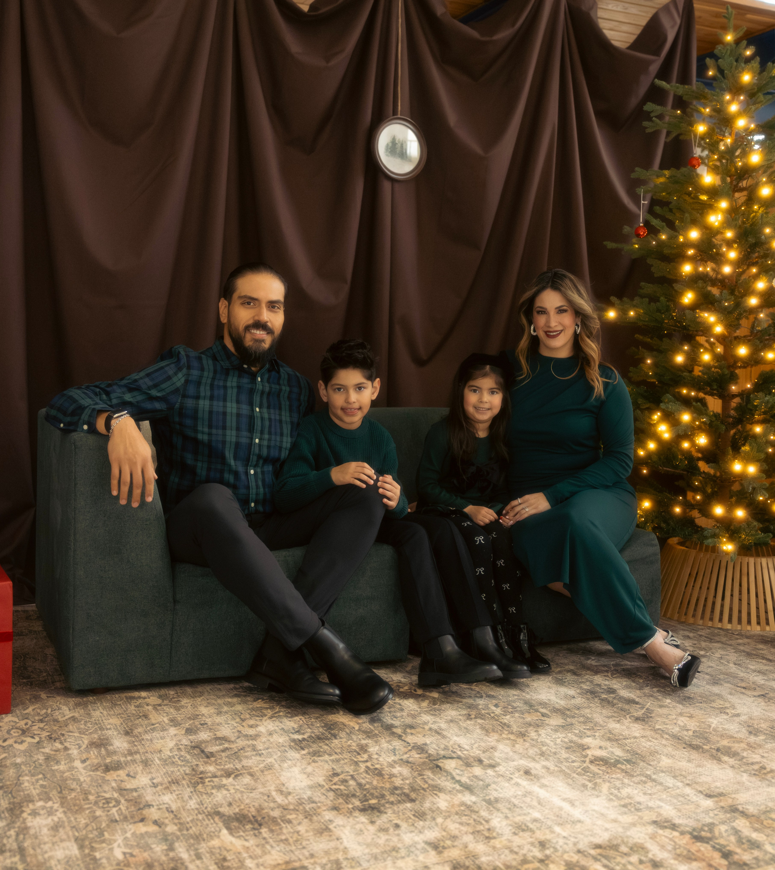 Family sitting together by the Christmas tree during a Christmas mini session in Chicago