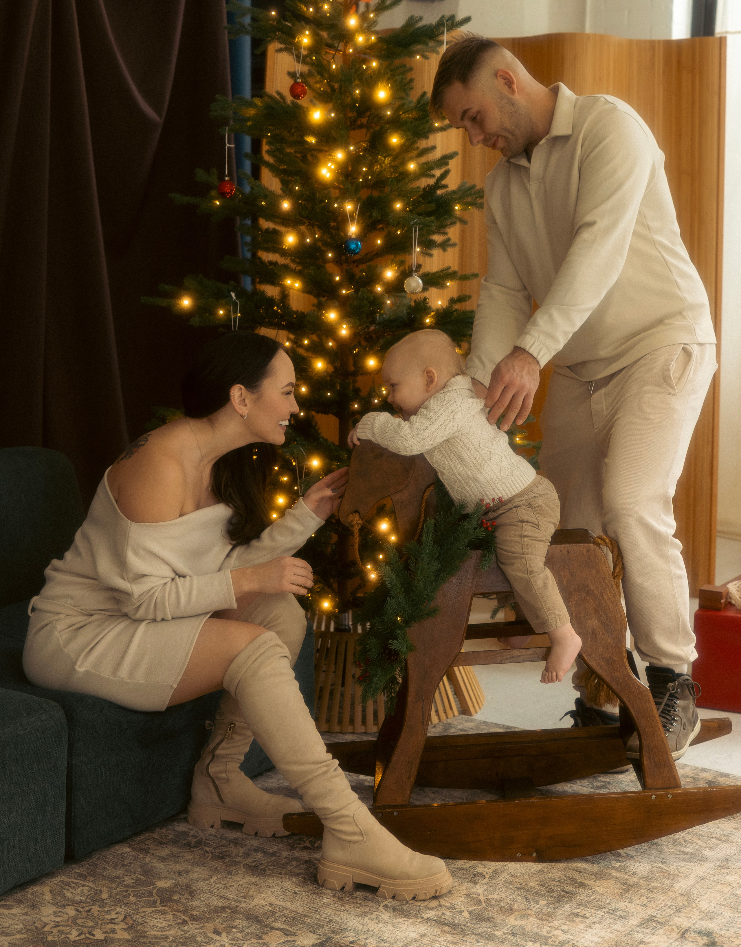 Parent and child playing by the Christmas tree during a holiday mini session