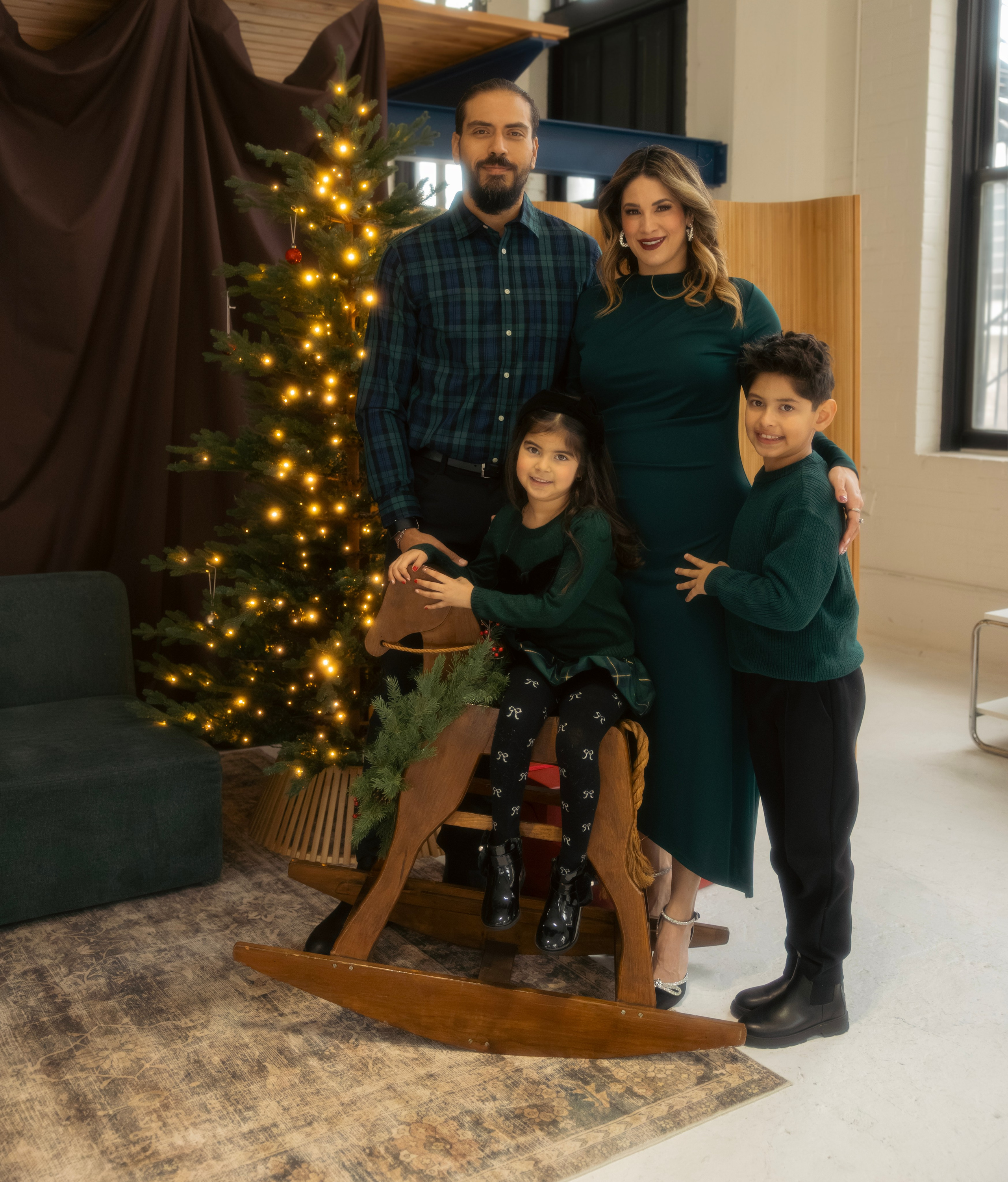 Parents and child decorating the Christmas tree together during a holiday family session