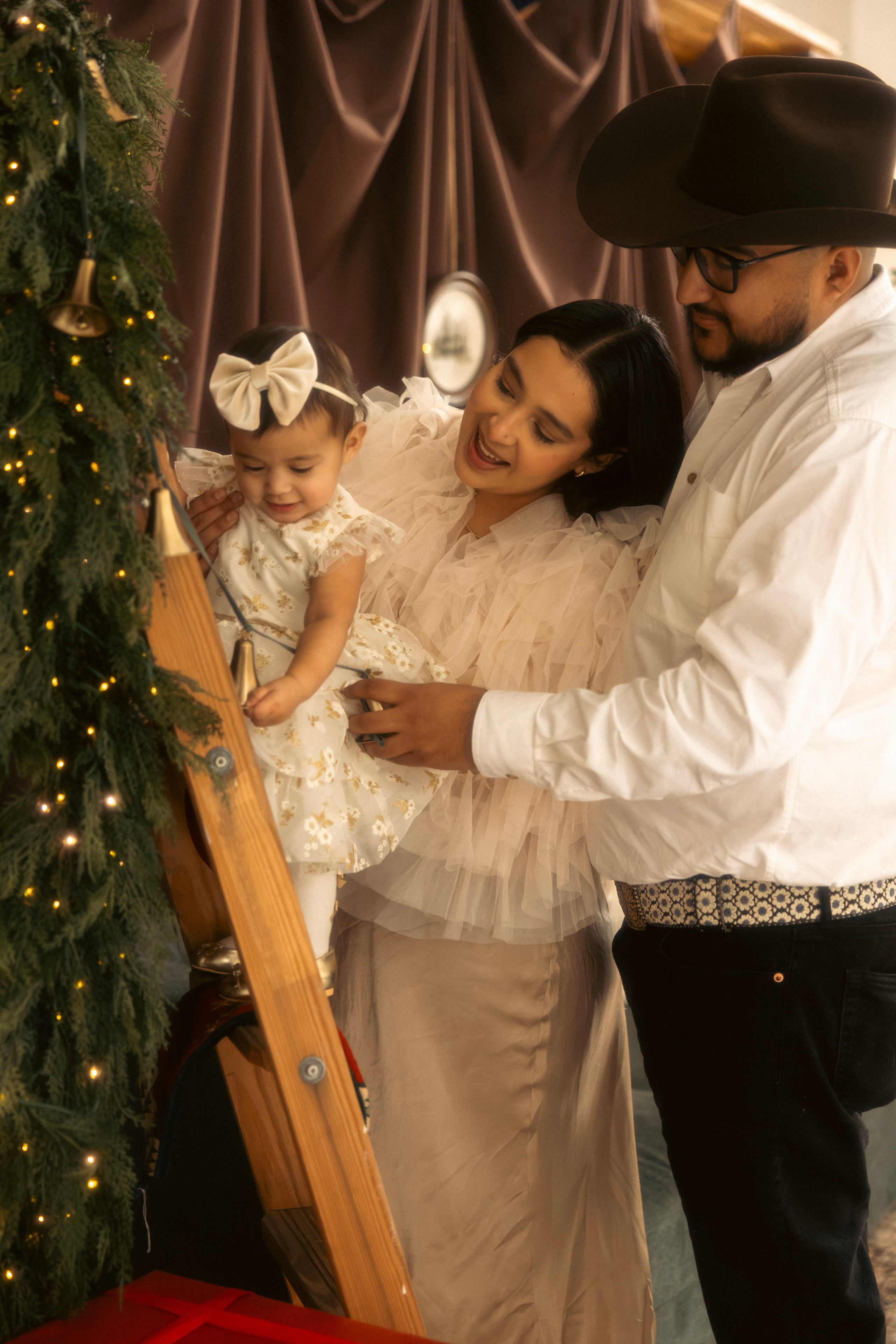 Child decorating a Christmas tree during a cozy holiday photo session