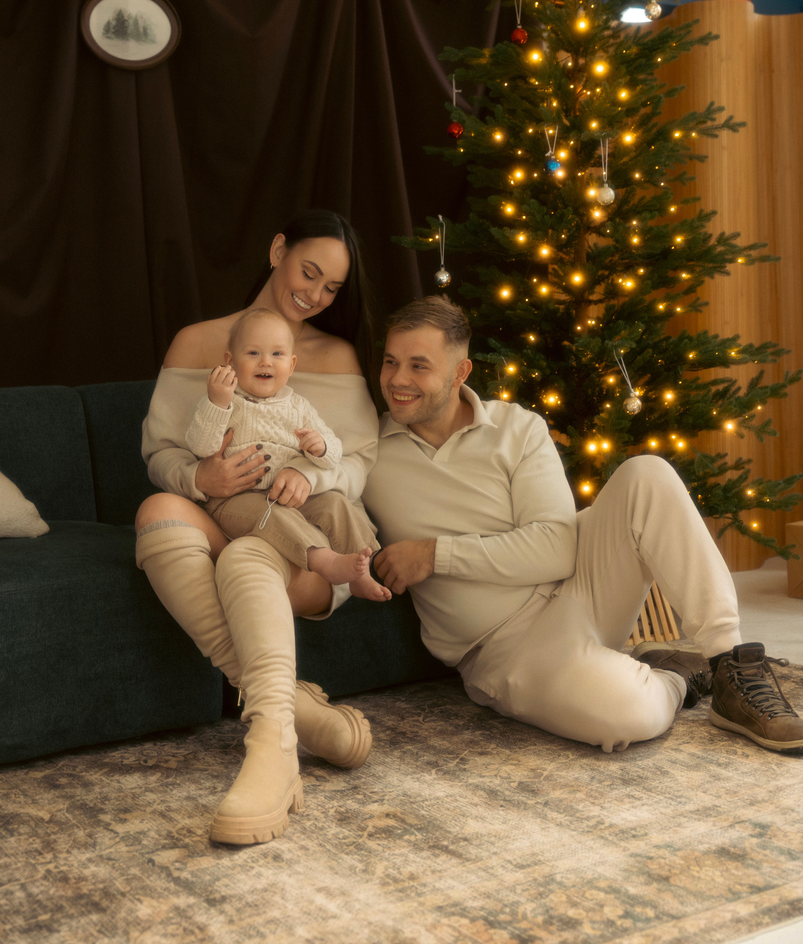 Father holding his child by the Christmas tree during a holiday mini session