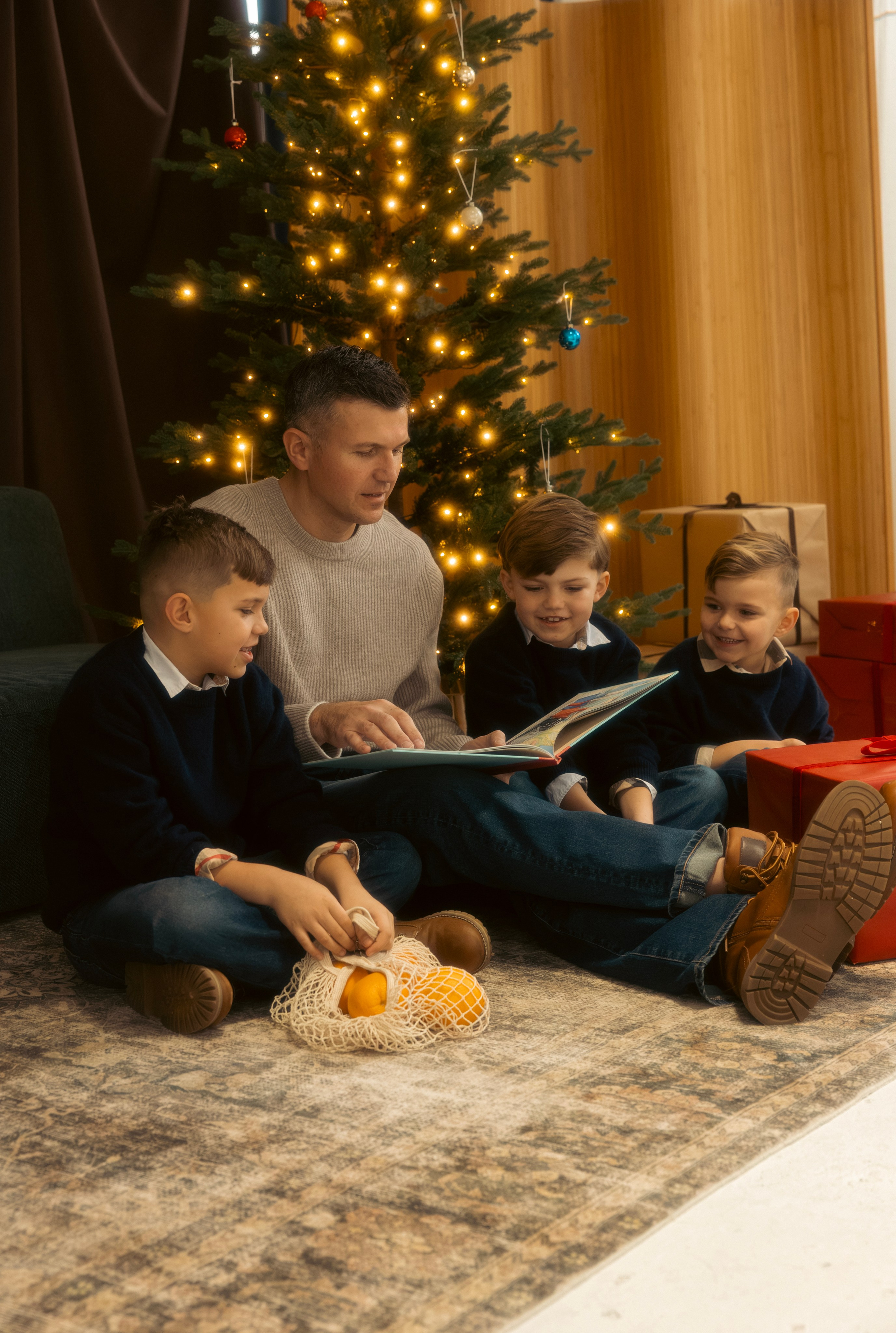 Family sharing a candid moment on the floor during a Christmas photo session