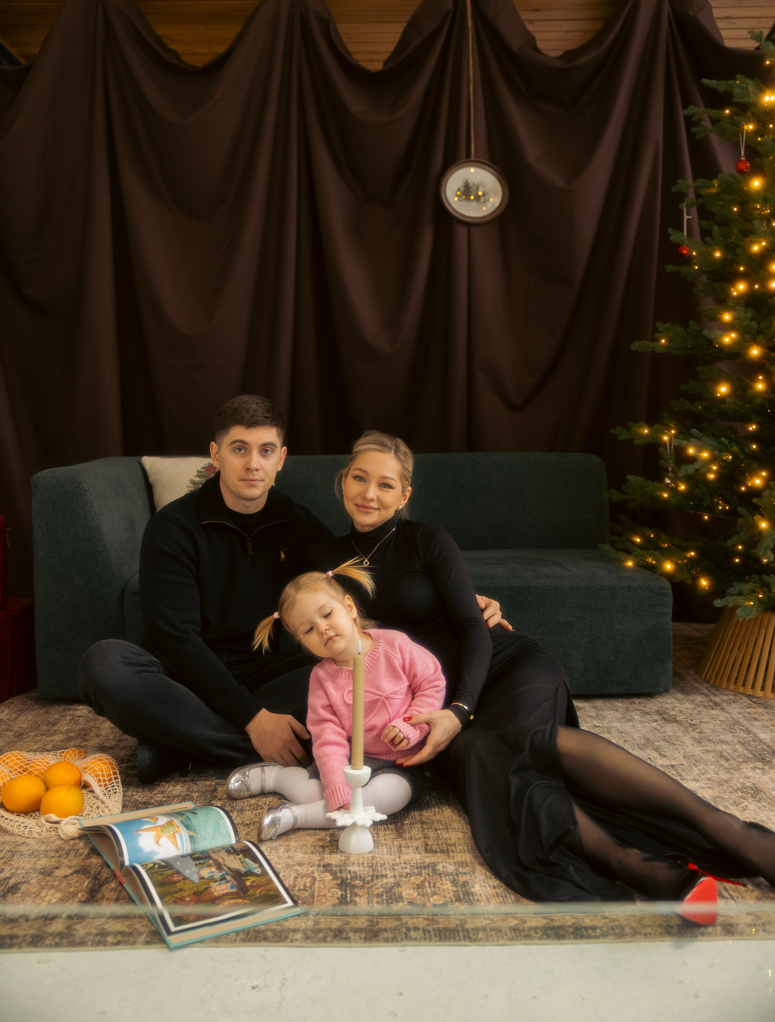 Family playing together by the Christmas tree during a cozy holiday photo session