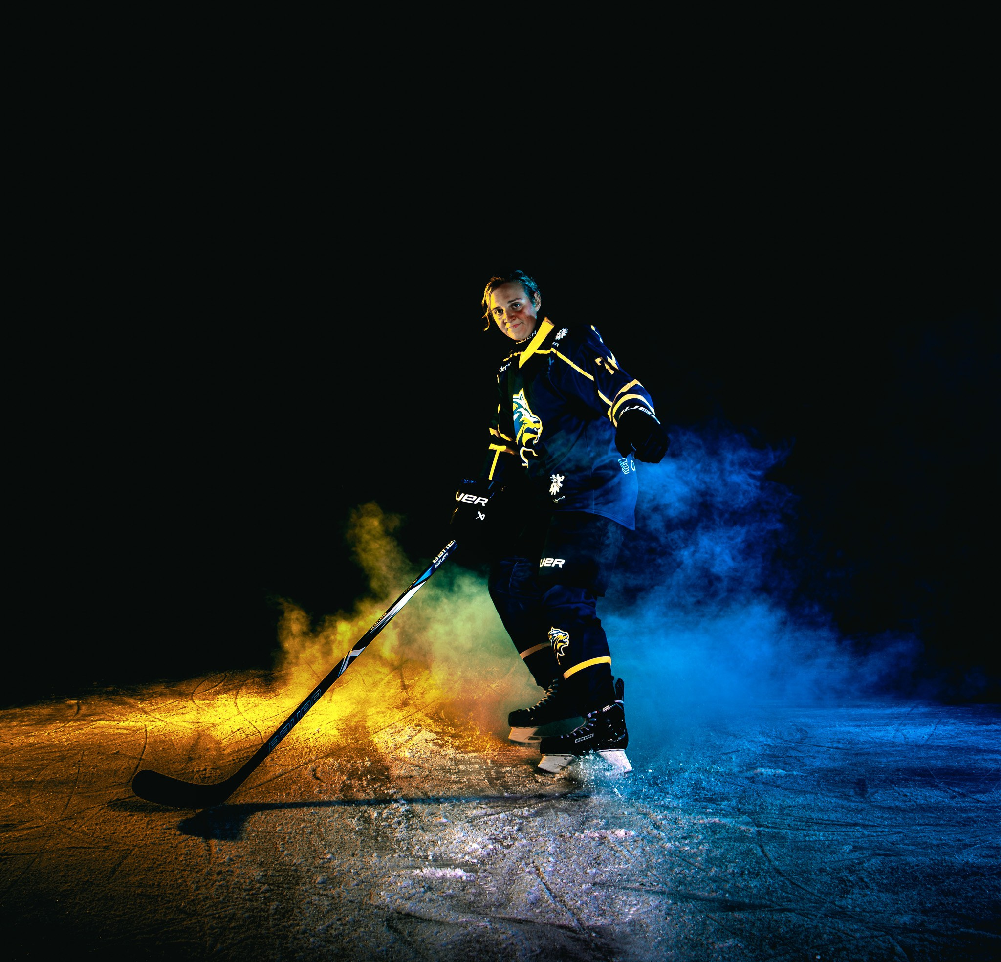 Krachtige portretfoto van ijshockeyspeler in clubkleuren - Kapture Fotografie