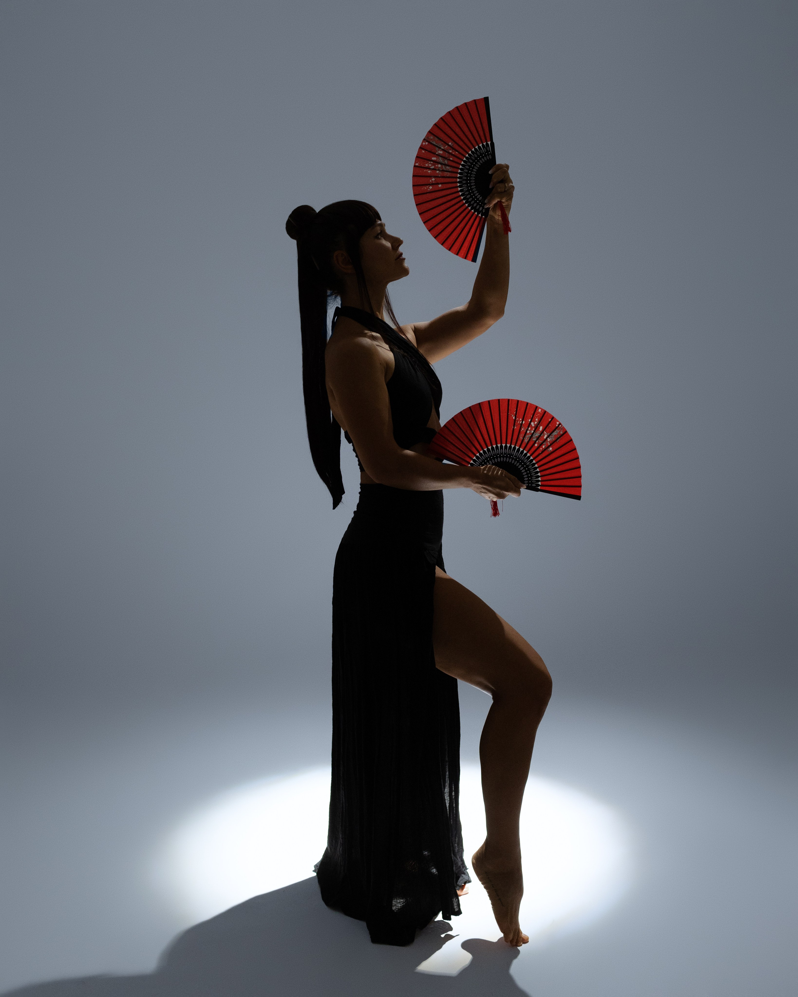 Japanisch inspirierte Studio-Porträtfotografie mit roten Fächern und Lichtakzenten