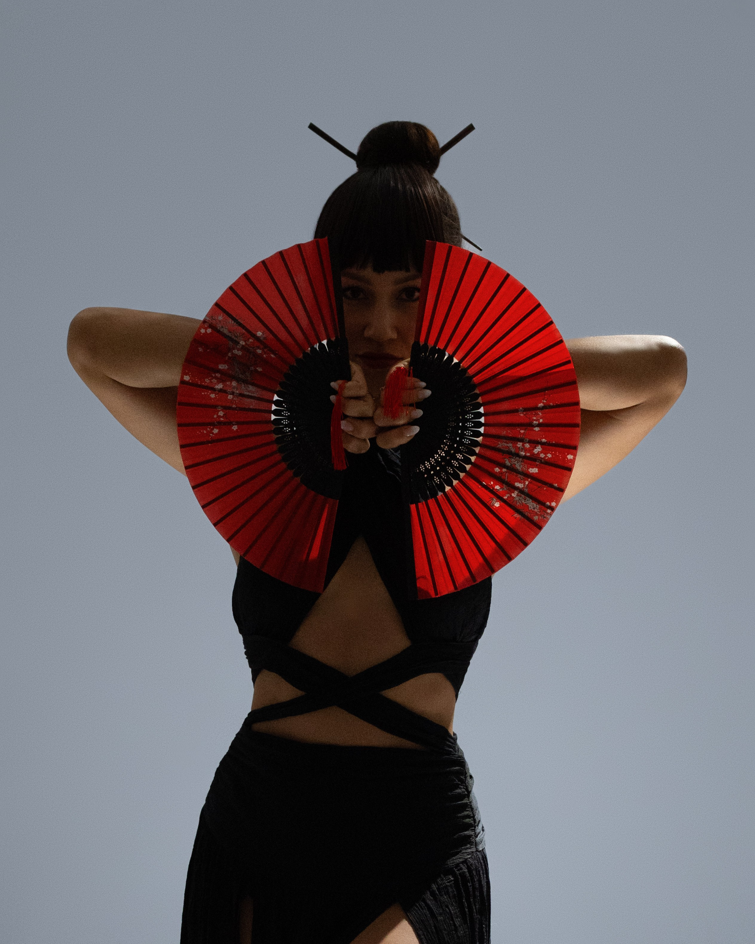 Japanisch inspiriertes Studio-Porträt einer Frau mit roten Fächern