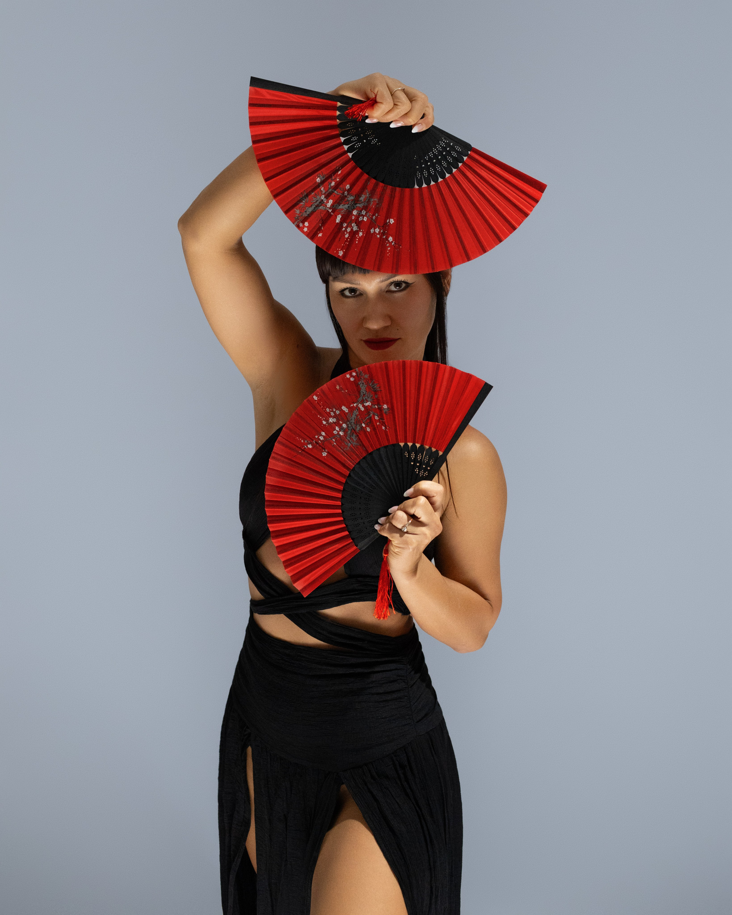 Frau mit roten Fächern bei einem japanisch inspirierten Studio-Fotoshooting