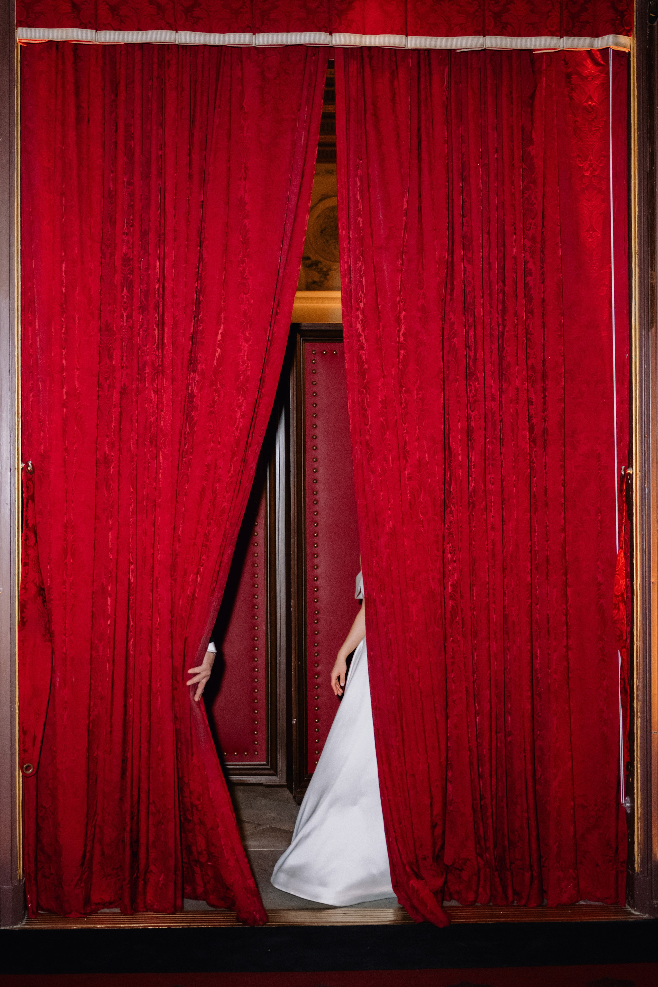 a woman in a white dress is standing in a doorway
