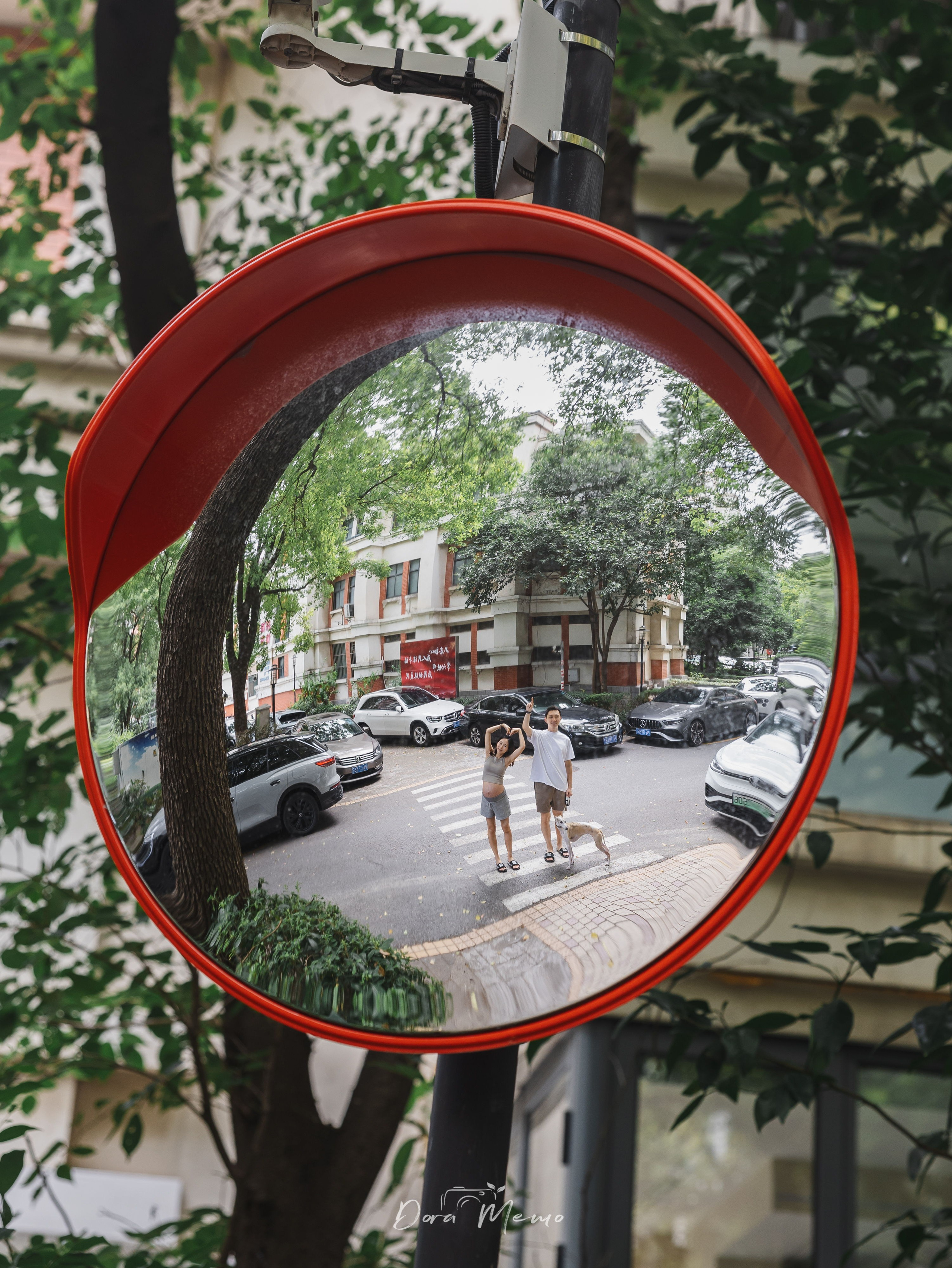 Quiet street mirror reflection of a couple walking their dog, ending an at-home maternity session in Shanghai.