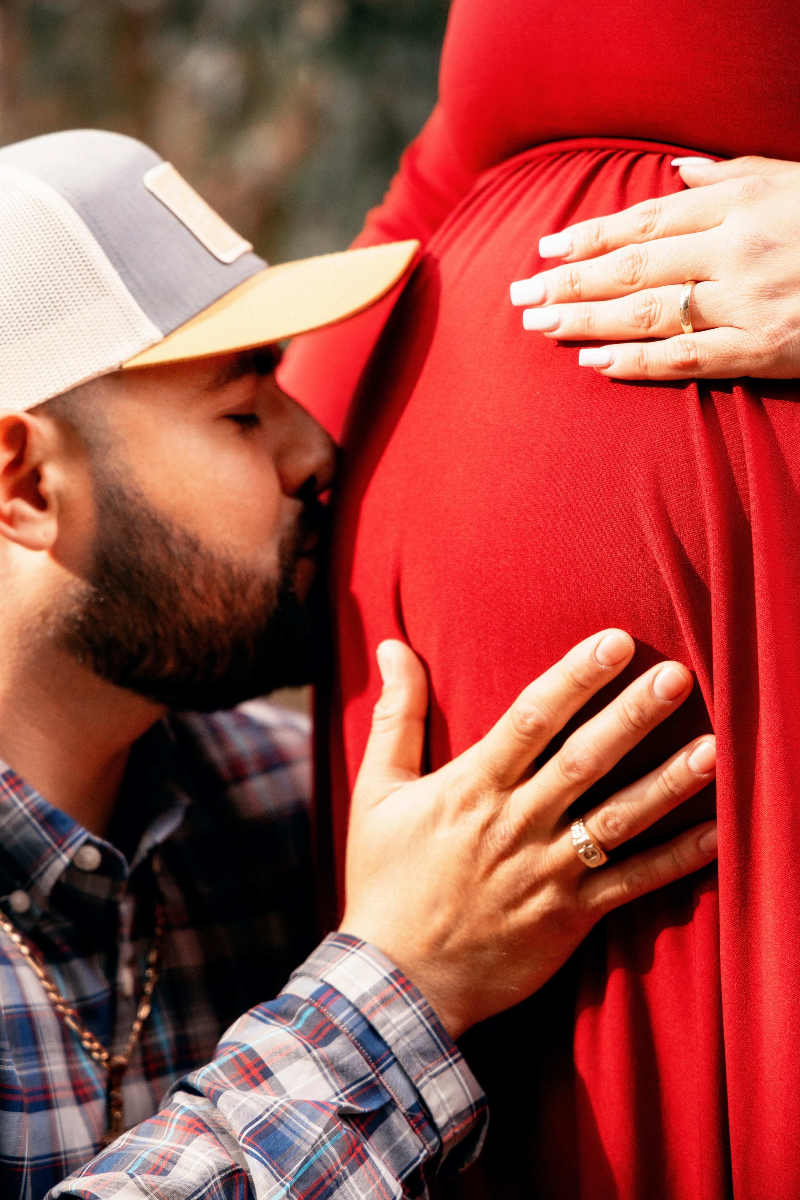 Expectant mother gently holding her belly on a forest path