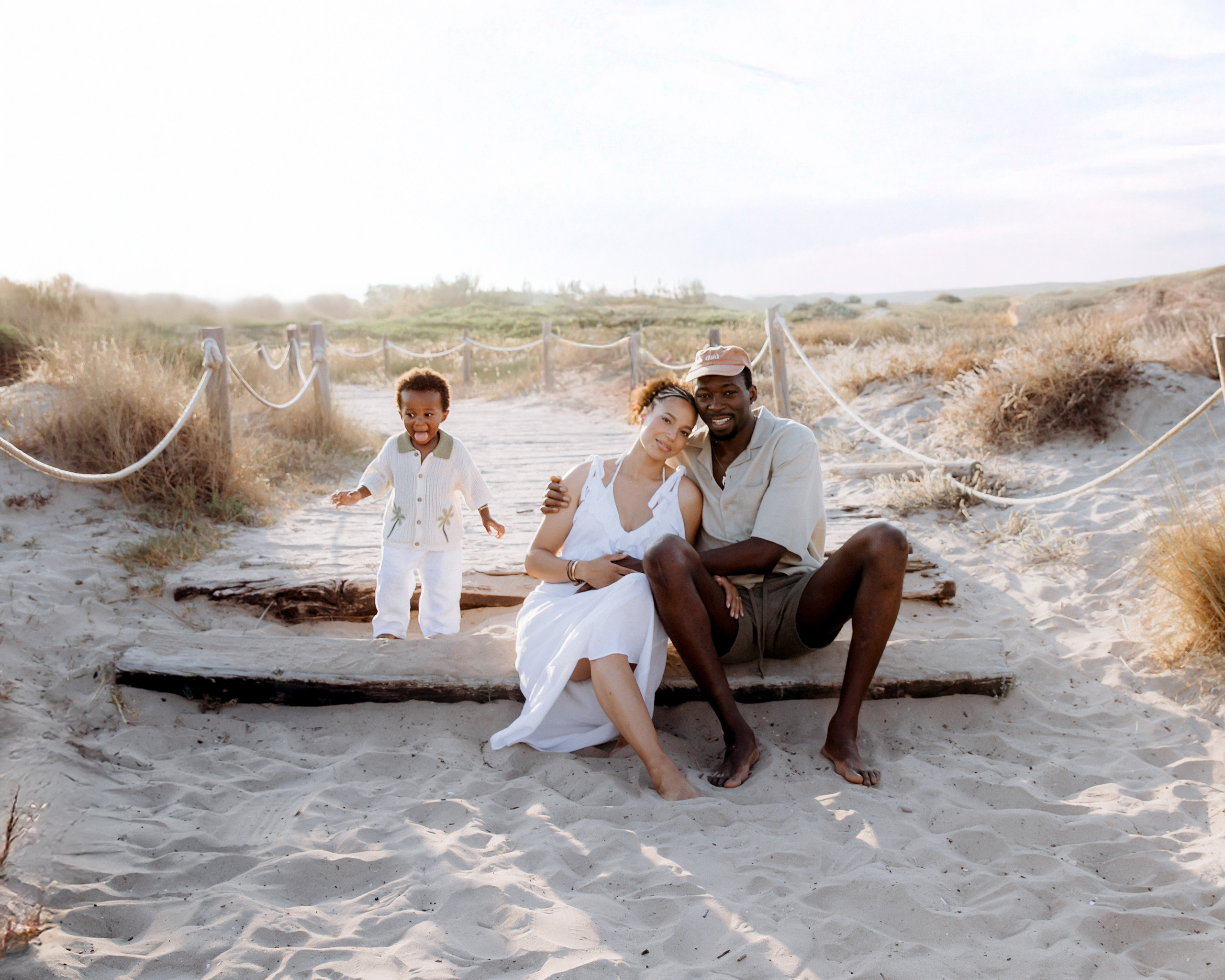Familia sonriente disfrutando de una sesión al atardecer en la playa de Valencia, España — capturando momentos alegres y naturales ideales para quienes desean fotos familiares relajadas y sinceras.
