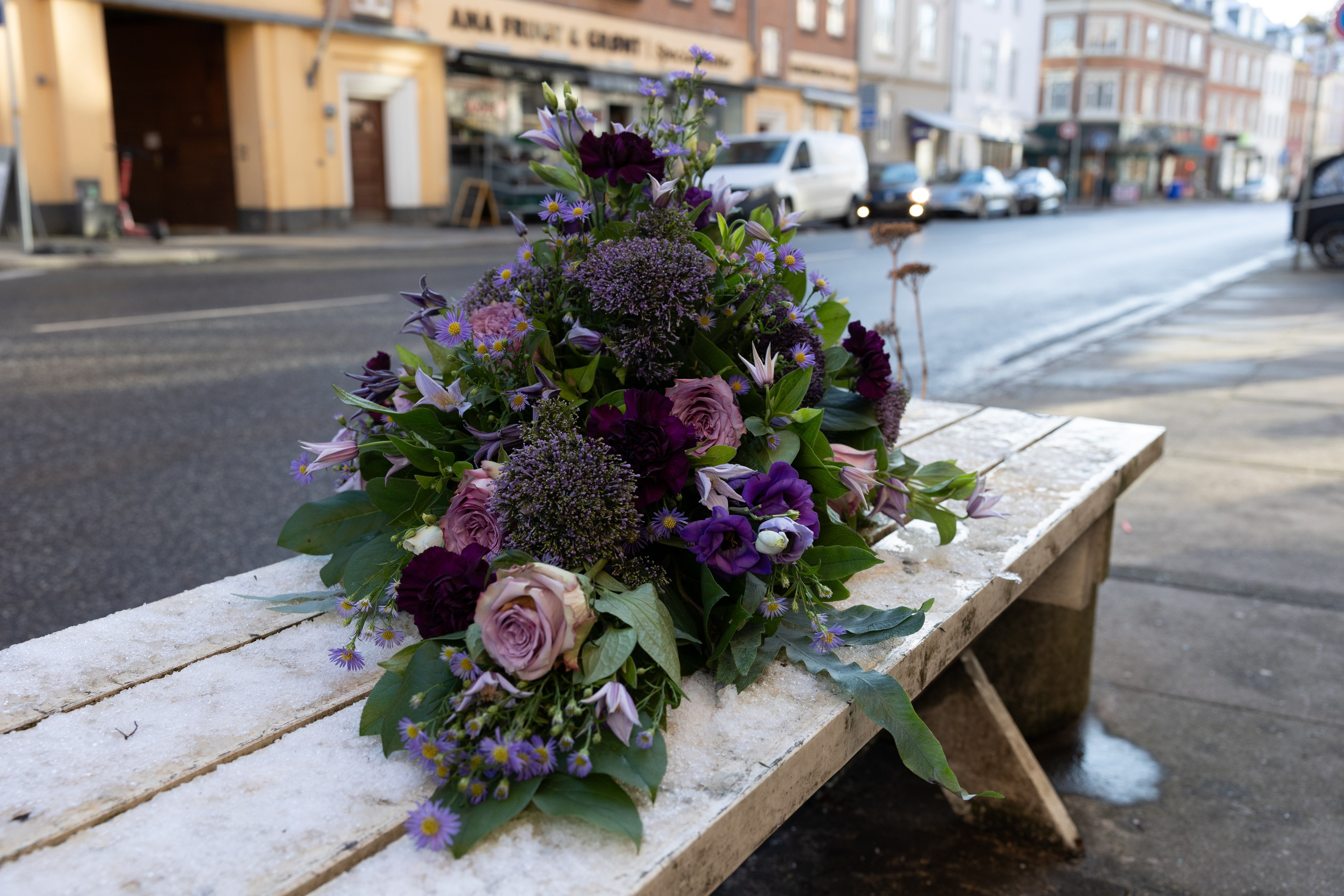Smuk båredekoration til at ligge på kirkegulvet. Opbygget i oasis med højde og længde på blomsterstilkene. i lilla nuancer. Denne unikke båredekoration er mere end bare en hilsen.