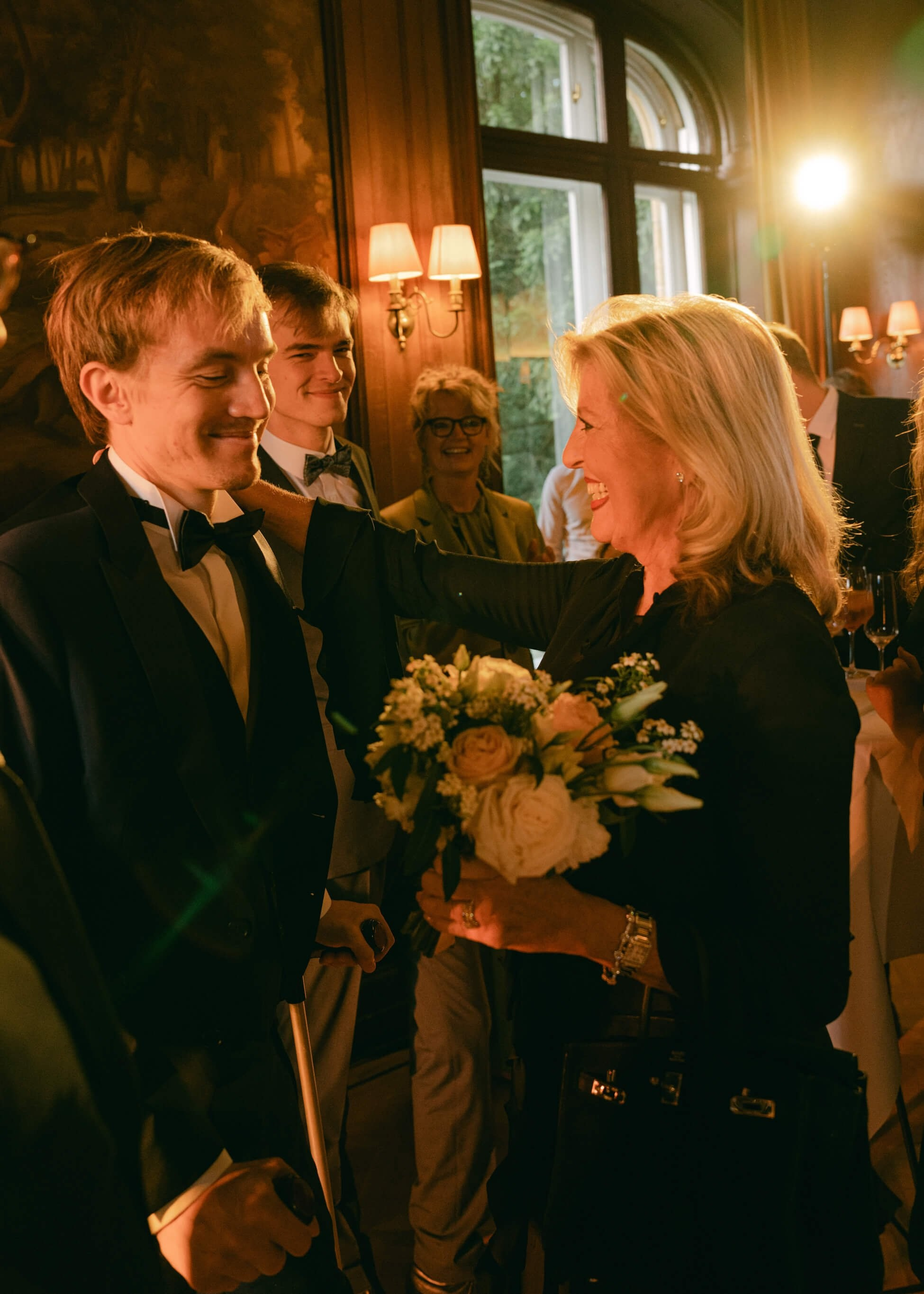 Groom in black tuxedo with wedding guest at cocktail reception, black tie wedding Villa Rothschild Frankfurt
