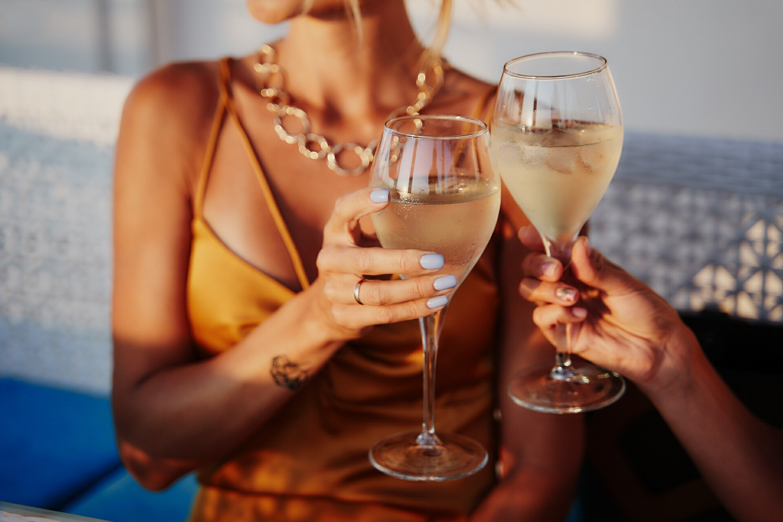 Woman holding champagne glass at sunset