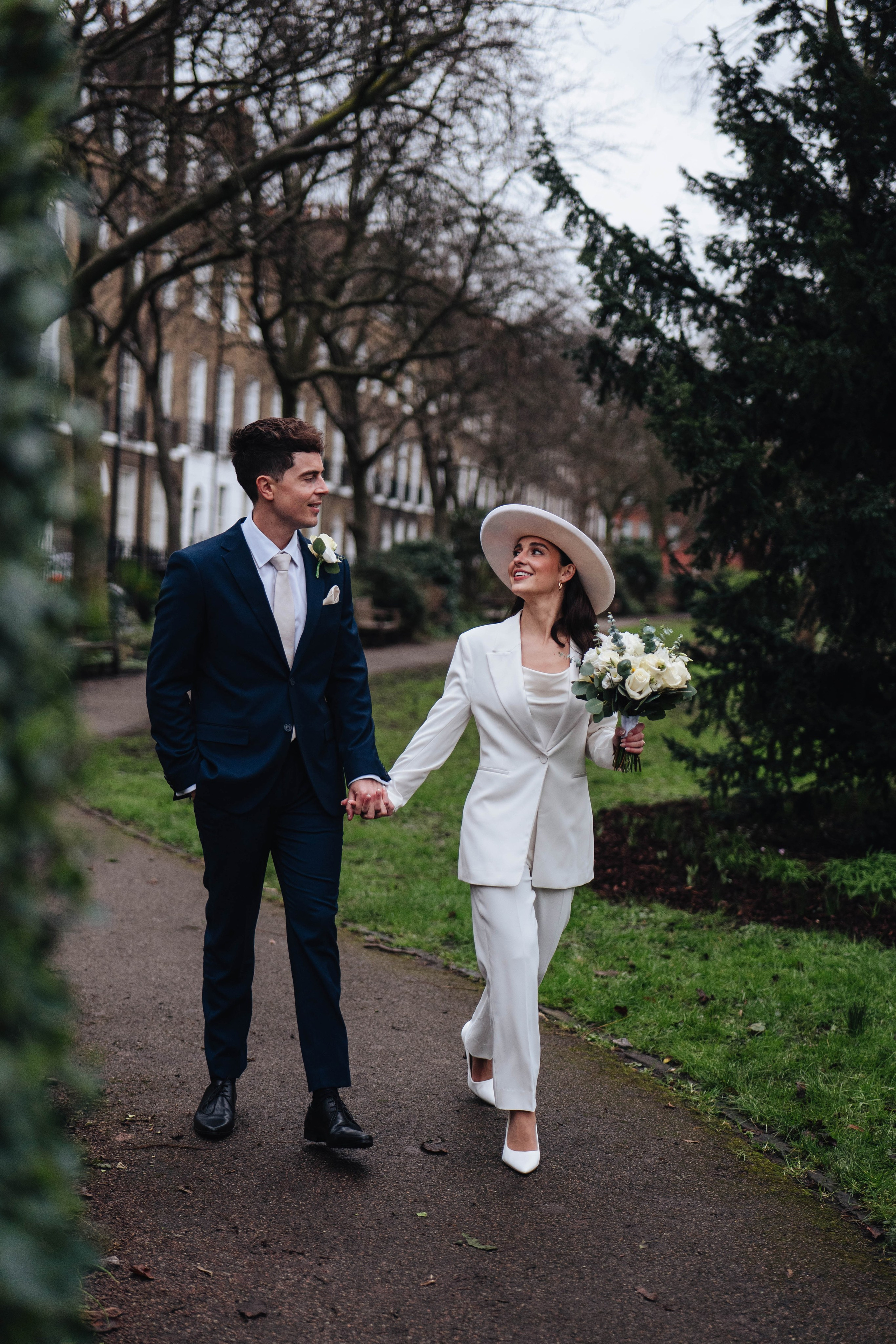 Stylish wedding in Islington, white women costume and white hat, walking in the green area