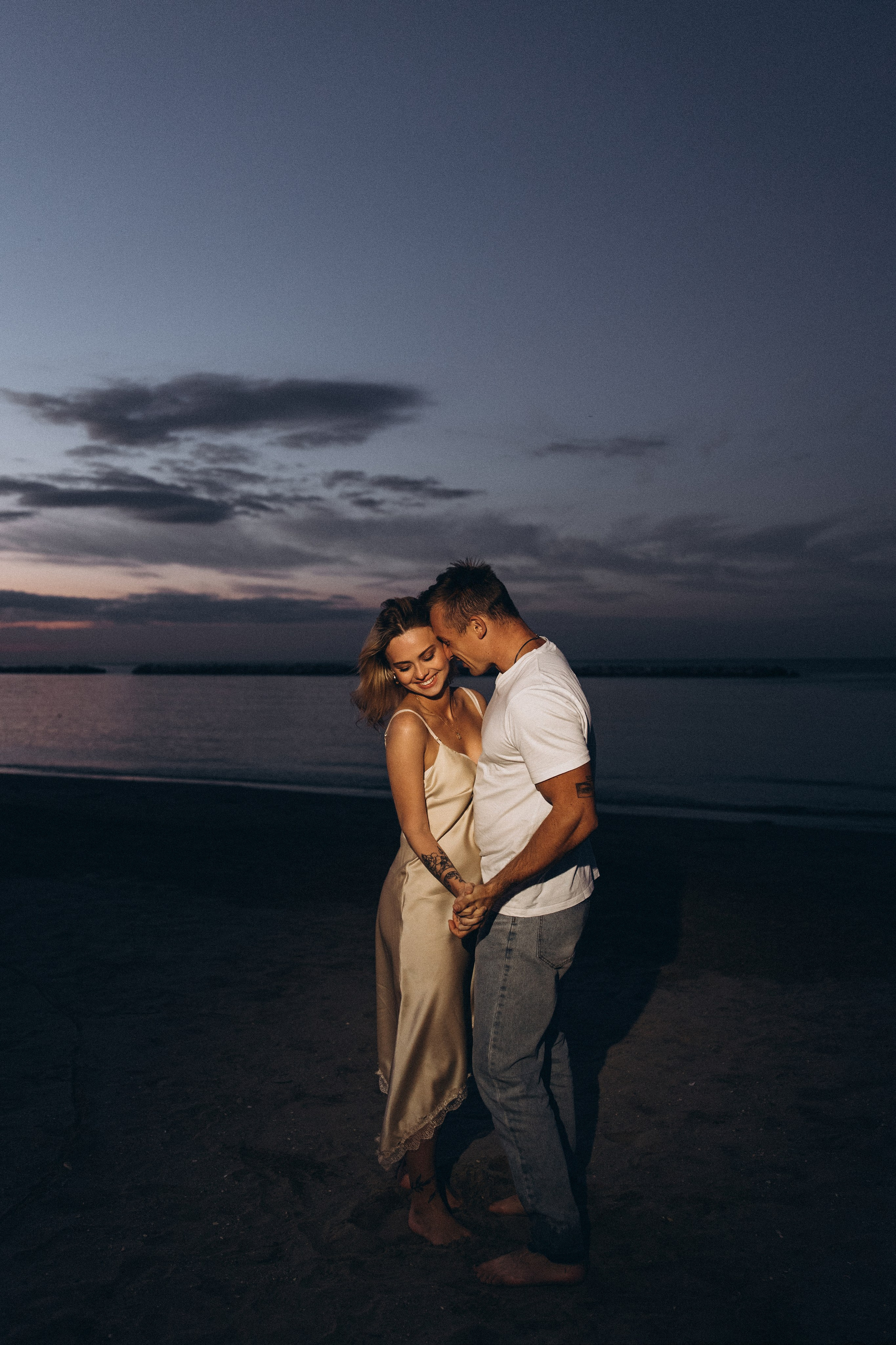 coppia sulla spiaggia al crepuscolo durante una sessione fotografica romantica a Rimini