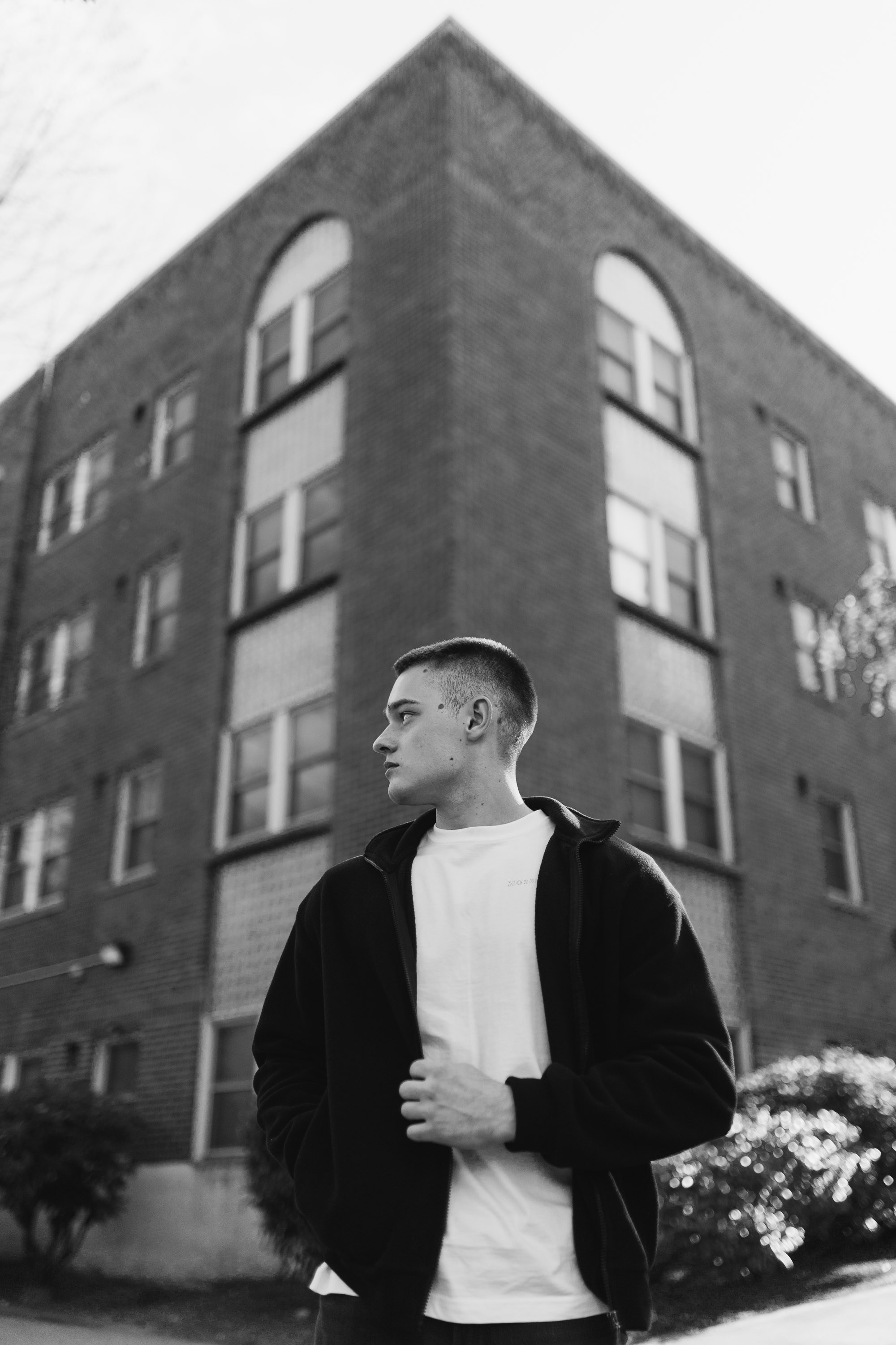 Man in coat standing near brick building