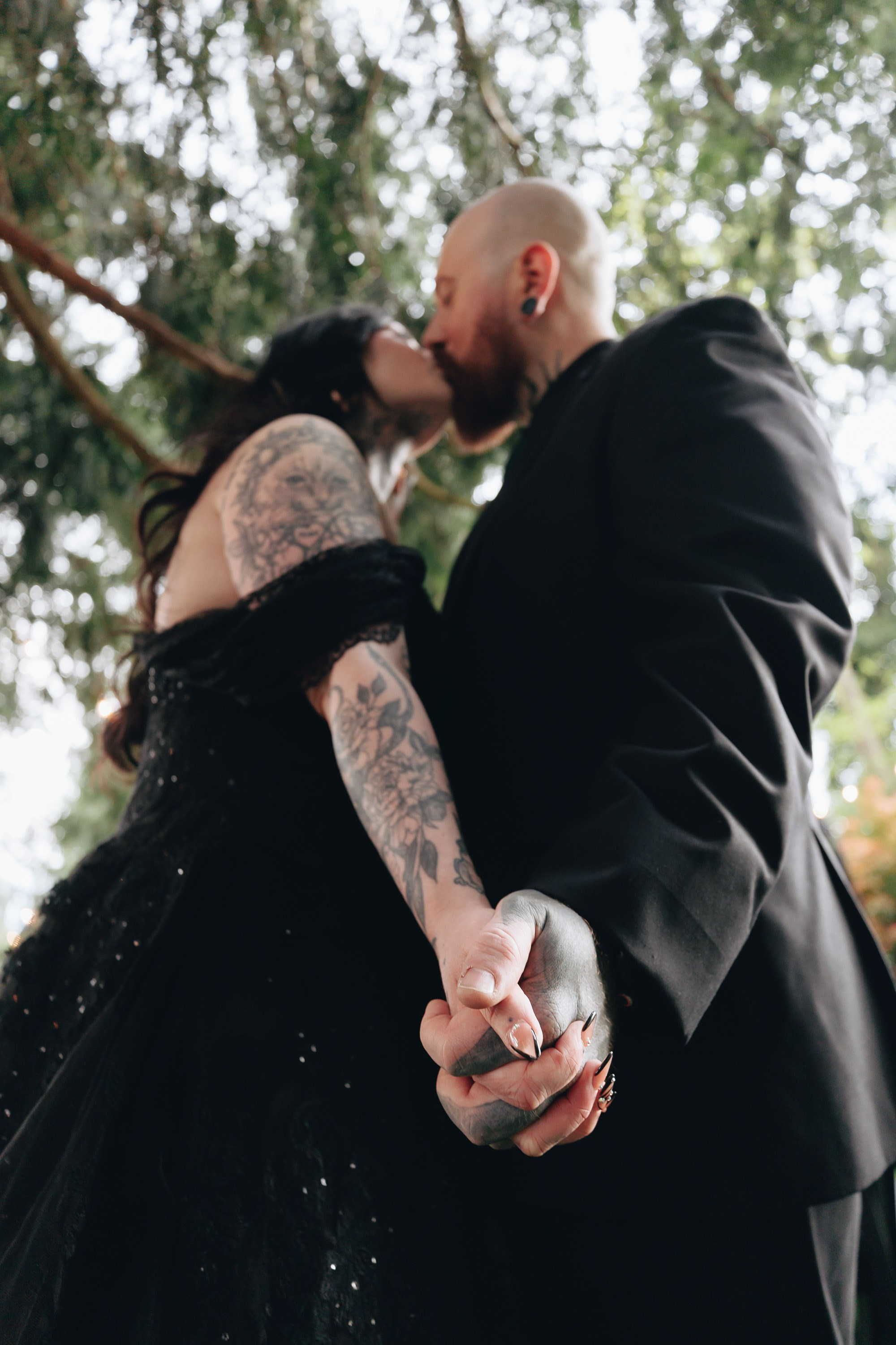 Groom lifting bride in joyful wedding moment outdoors