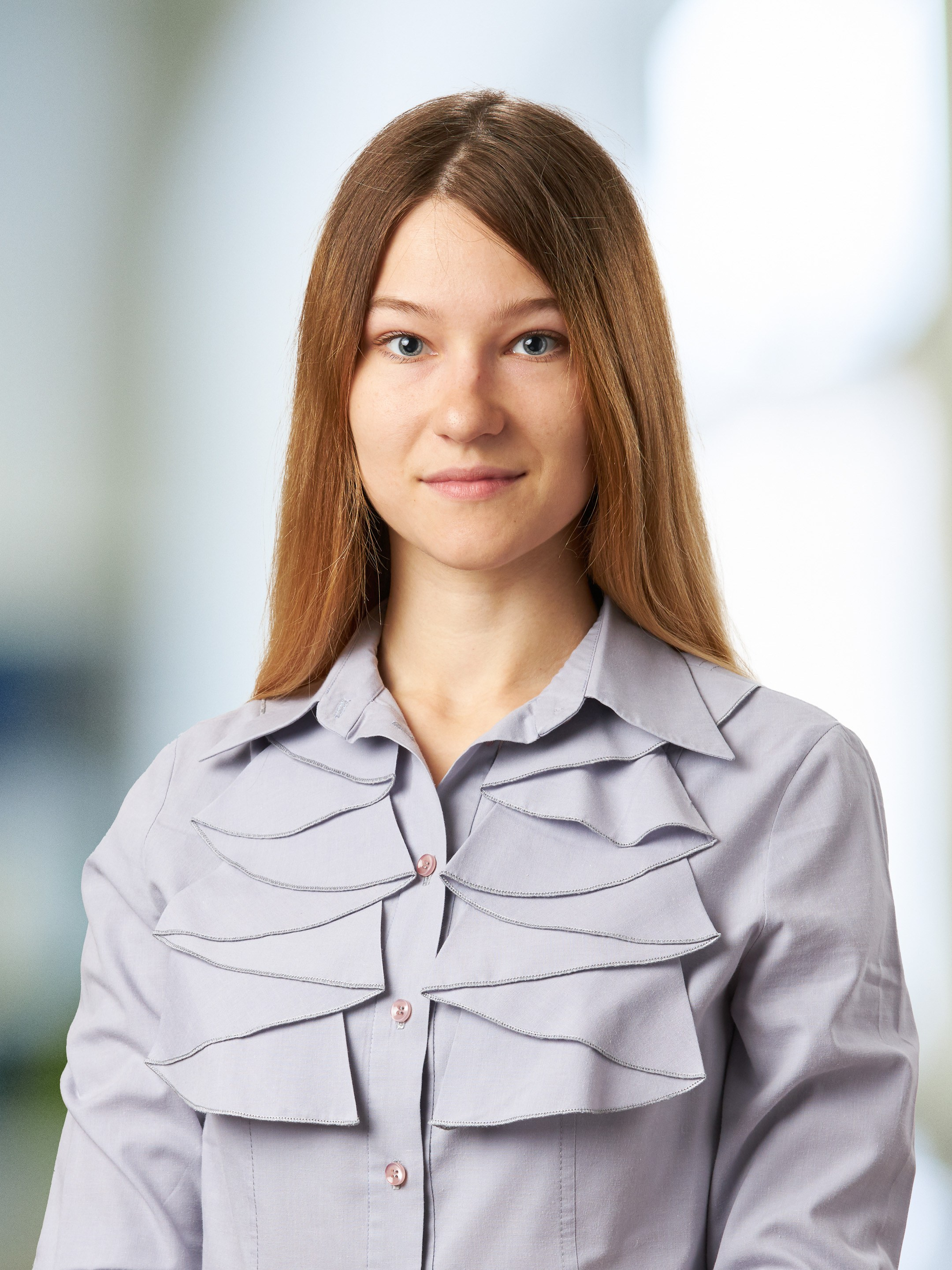 Business portrait of a young woman against a blurred office background - photographer Andrey Dunin
