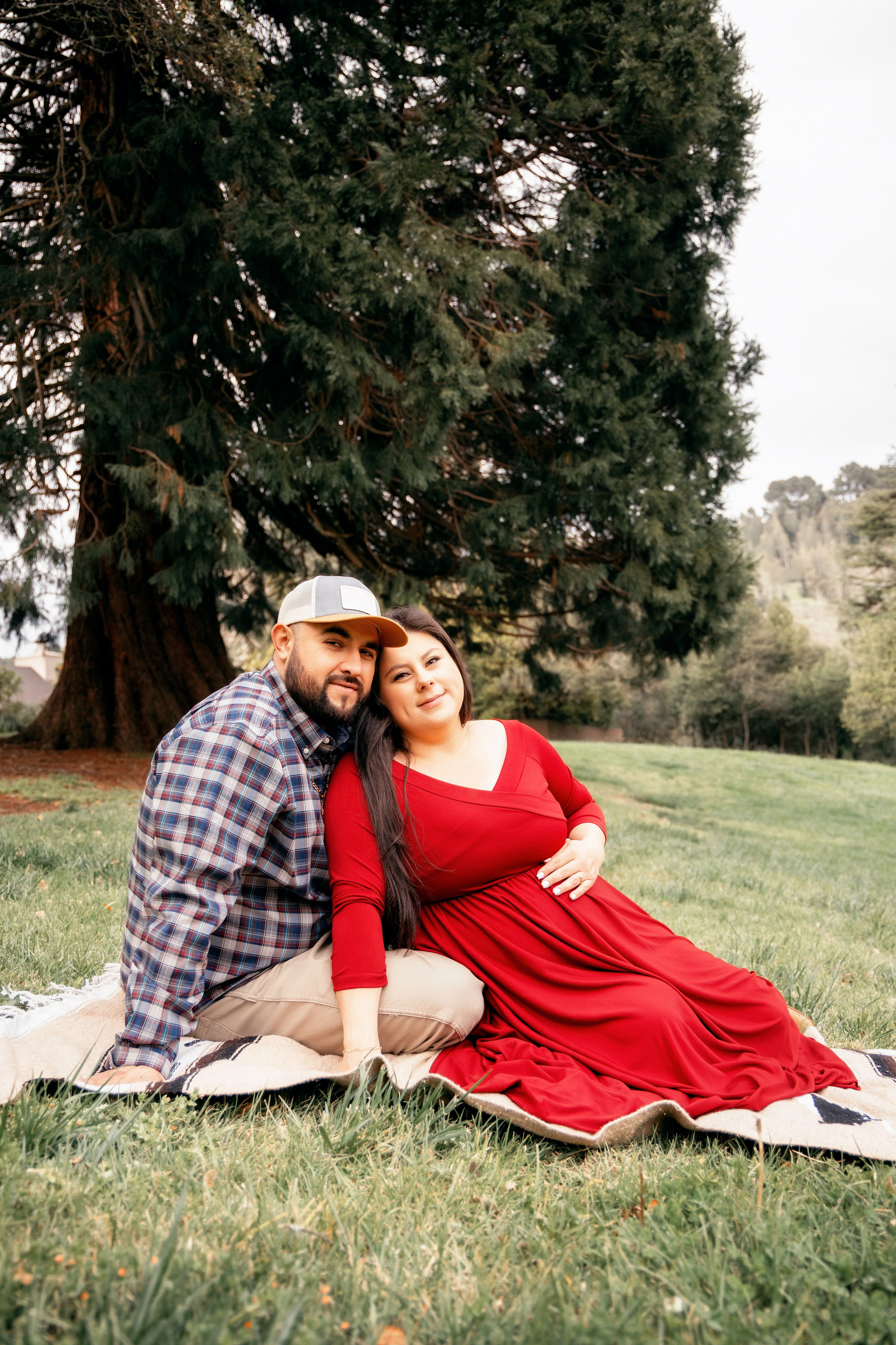 Expecting parents enjoying nature during a maternity photoshoot in the park