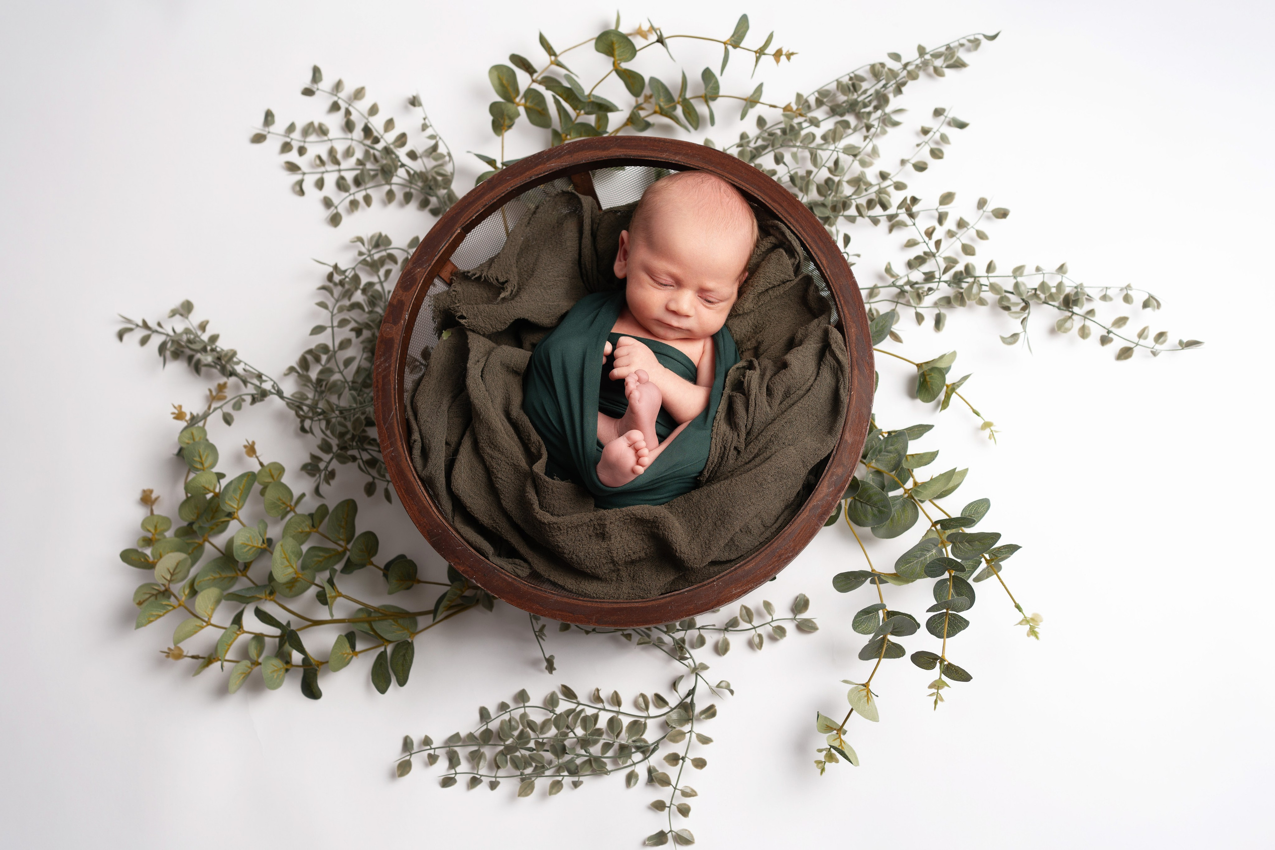 Baby zusammengerollt in batanischer Deko