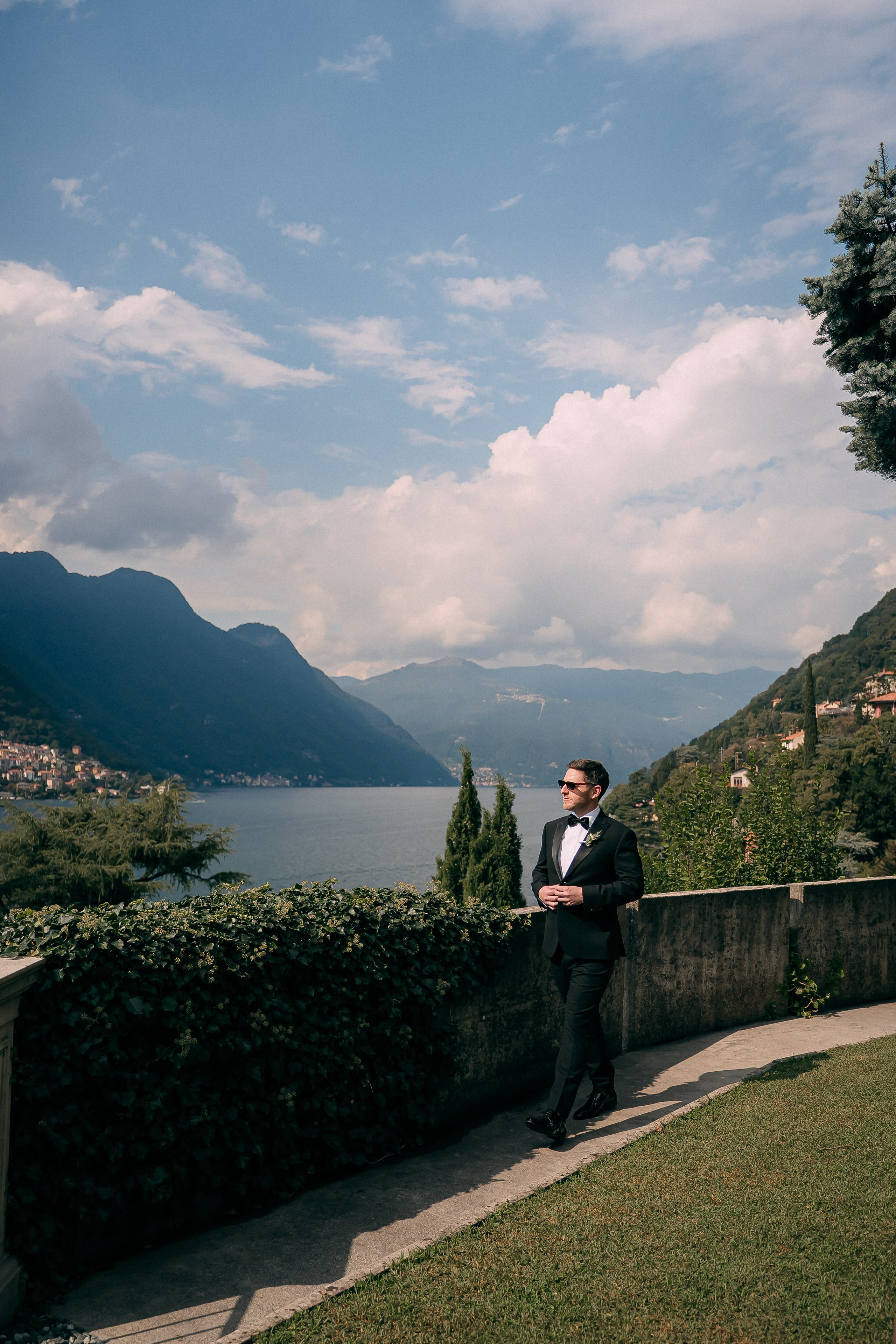 Groom in a tuxedo on the balcony with Lake Como views at Villa Lario, Italy