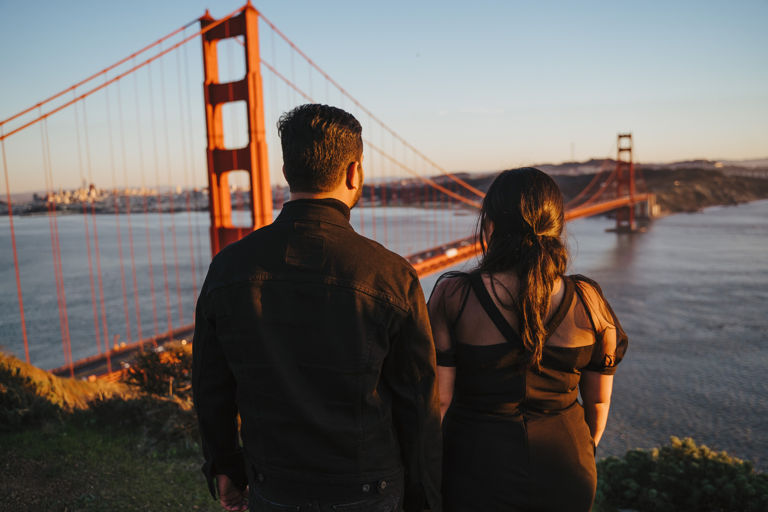 Proposal.  Overlooking the golden San Franisco Bridge sunset with a couple. Photographer Video. 