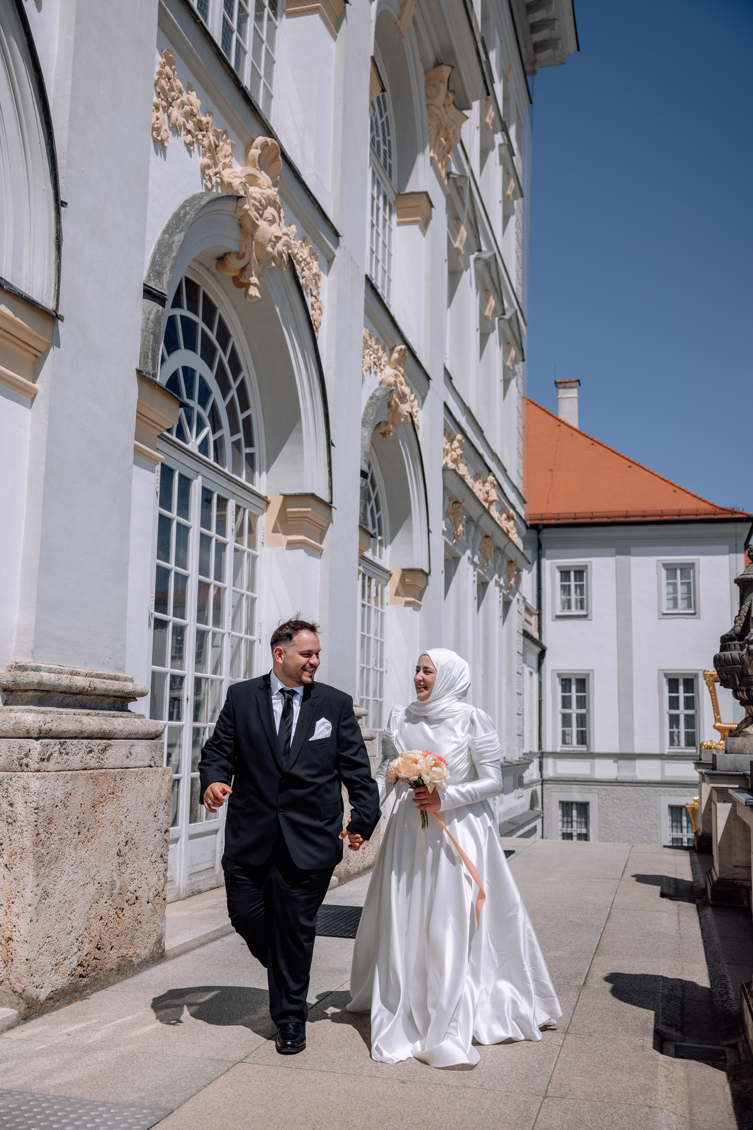 Paar spaziert Hand in Hand vor dem Schloss Nymphenburg