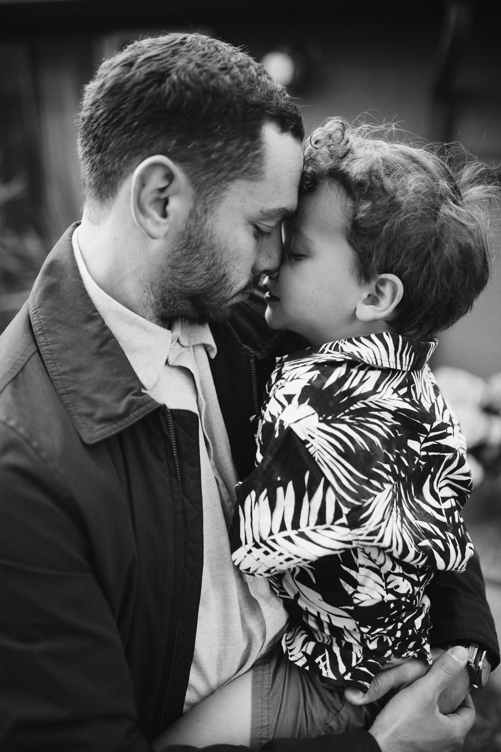 Dad and son touching foreheads, black and white portrait
