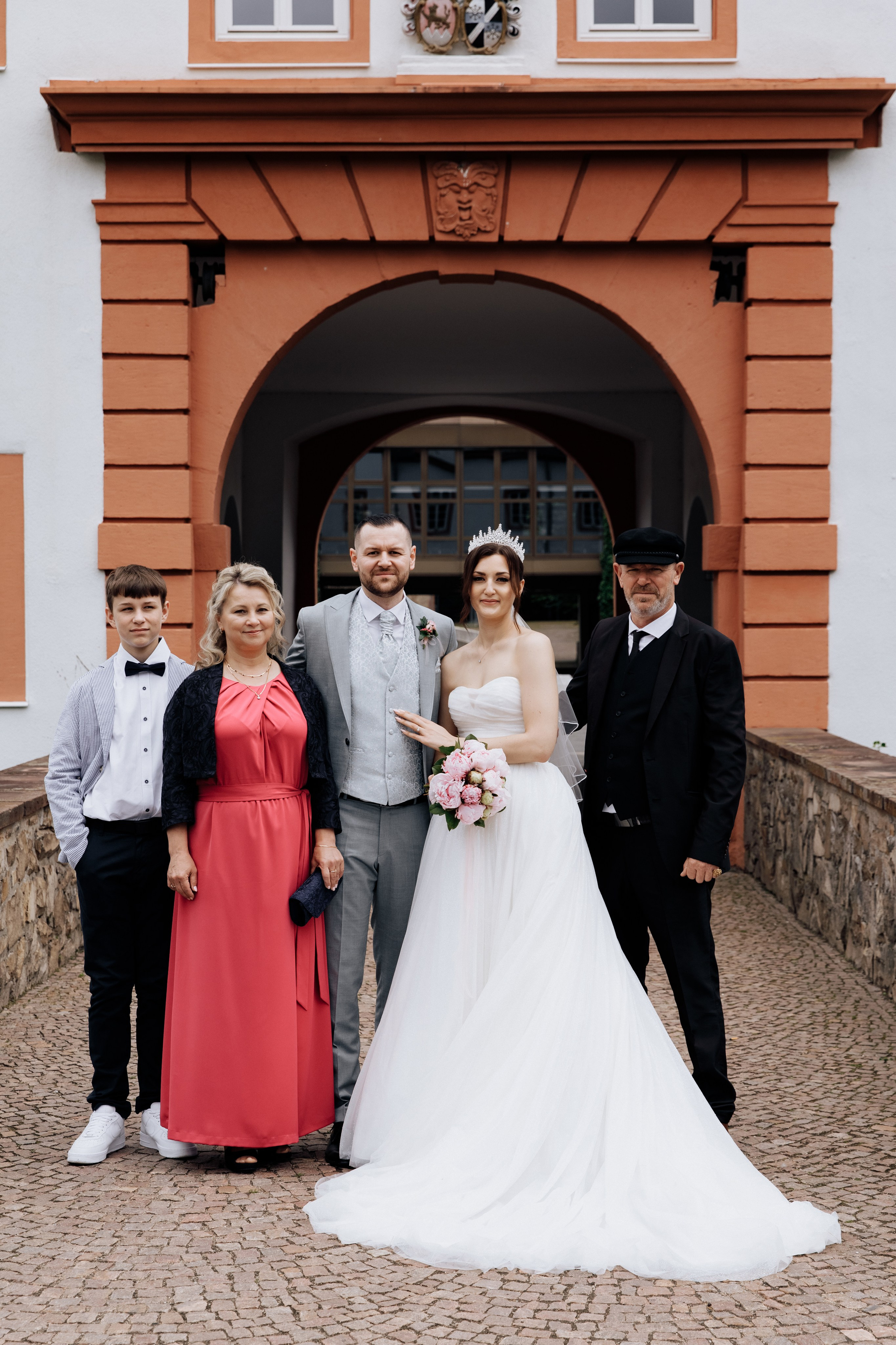 Familienporträt des Bräutigams, der Braut und der Eltern des Bräutigams. Ein bedeutungsvoller Moment der Hochzeitsfeier.