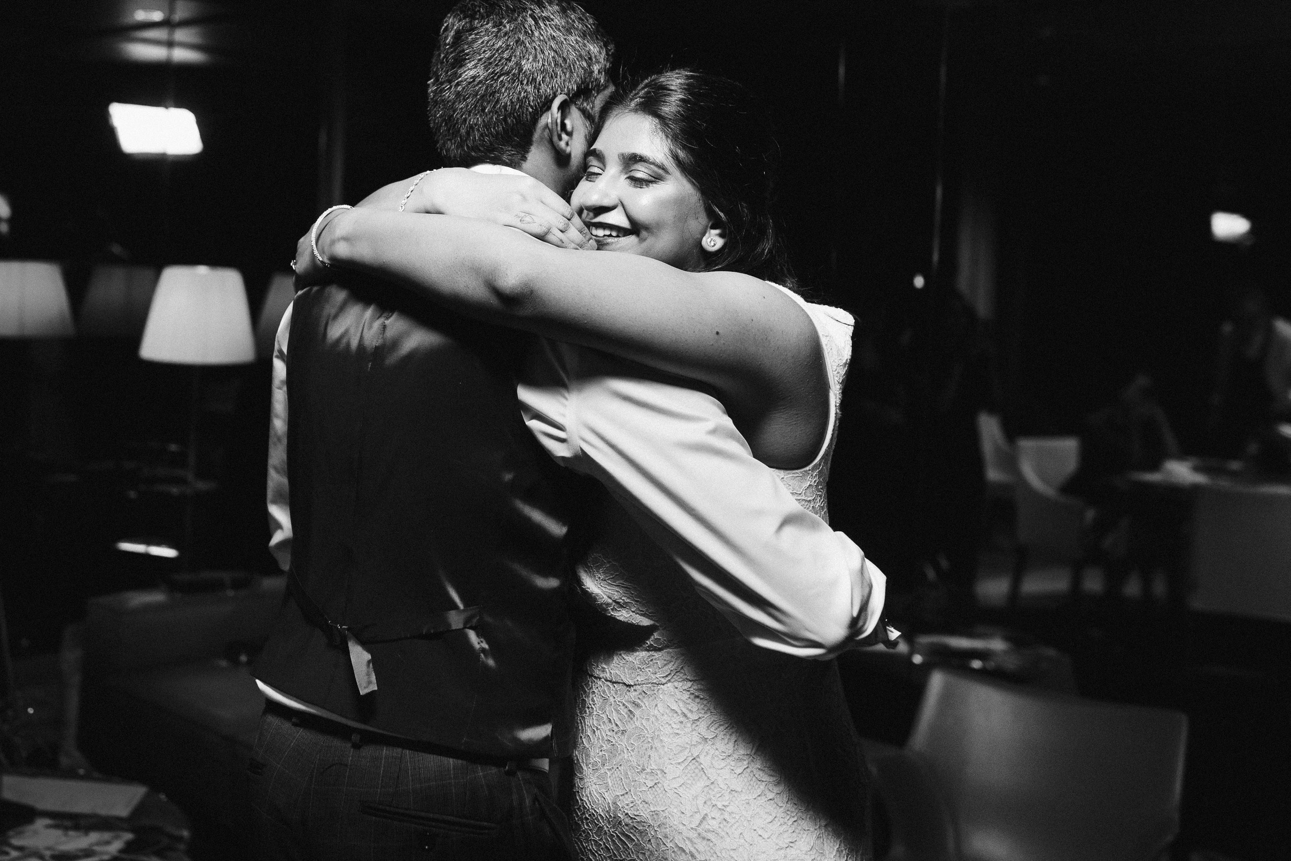 Couple hugging in black and white, emotional wedding moment