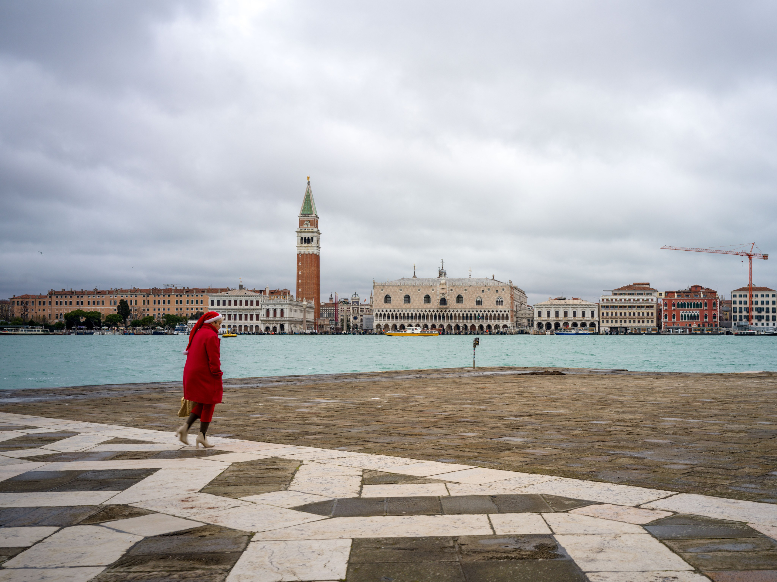 San Giorgio Maggiore in Venice with lone person in red coat on waterfront