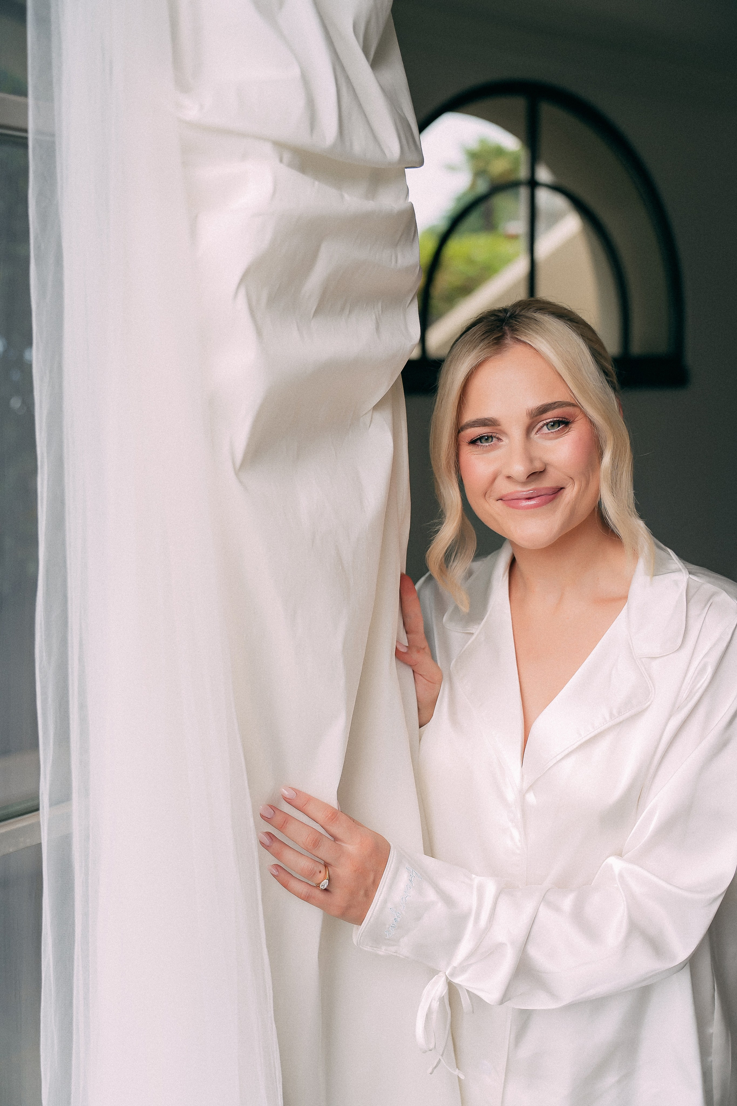 Joyful bride by the window curtains at Villa Lario, Lake Como, Italy