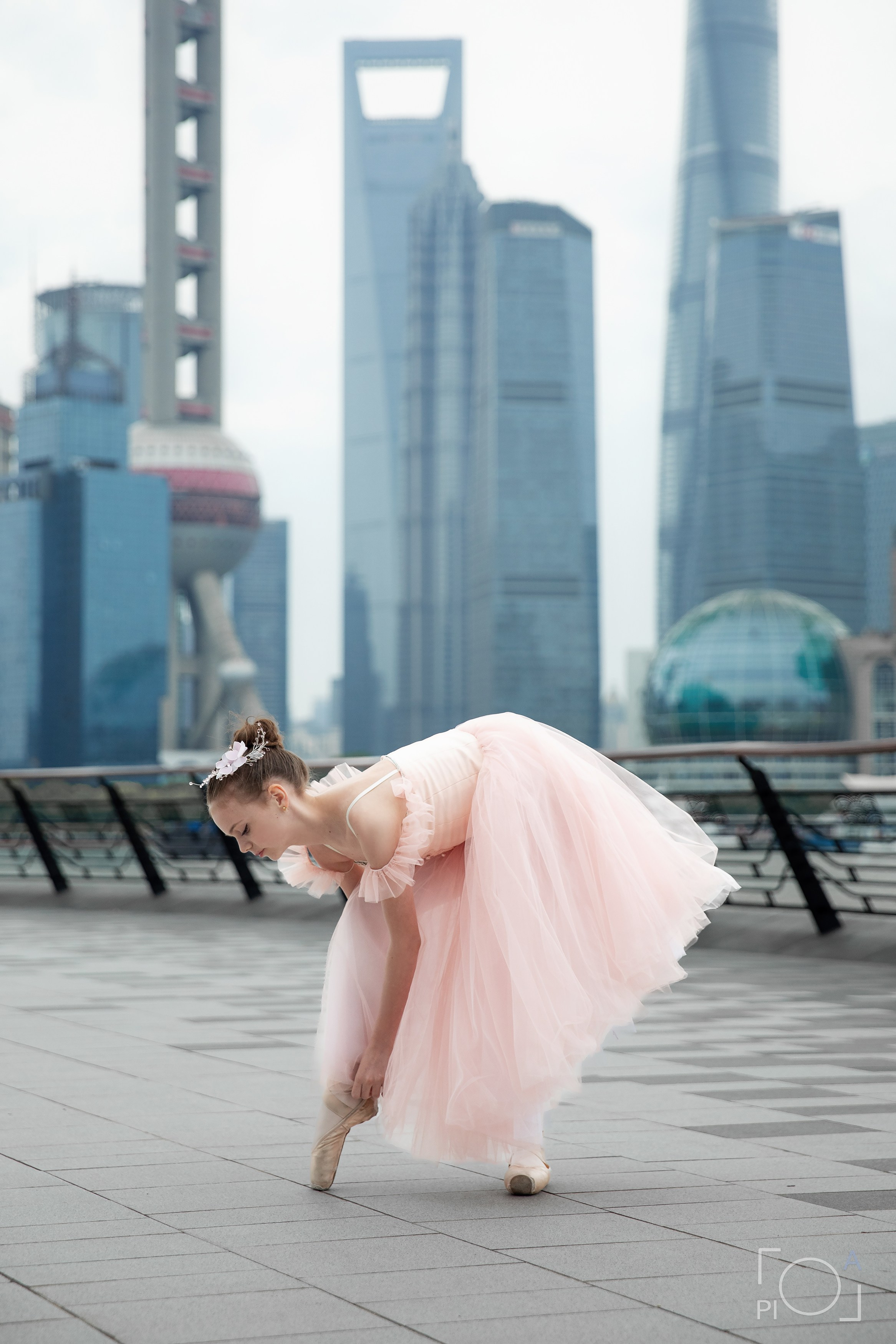 Фотосессия в Шанхае для девочки 11 лет. Маленькая балерина в розовом платье с пышной длинной пачкой, танцует на набережной в Шанхае с видом на Lujiazui